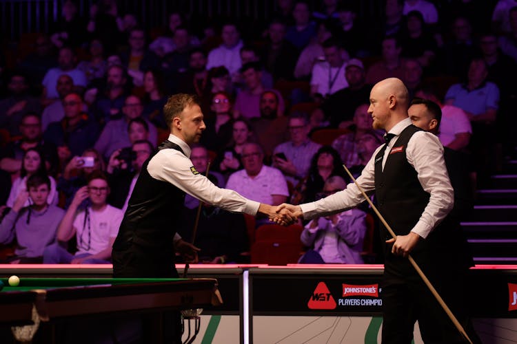 Two snooker players shaking hands 