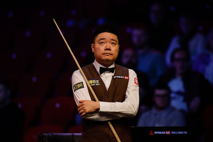 Player standing with a cue stick 