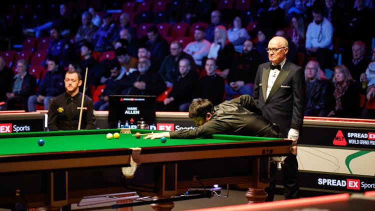Two snooker players with a referee