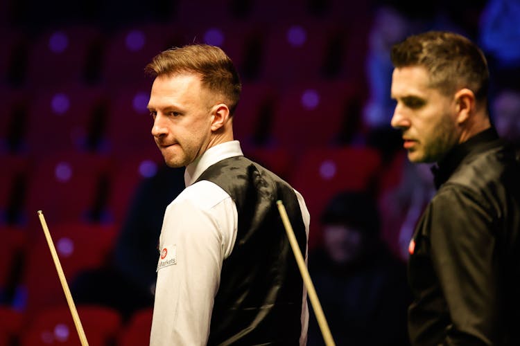 Two snooker players with their cue sticks 