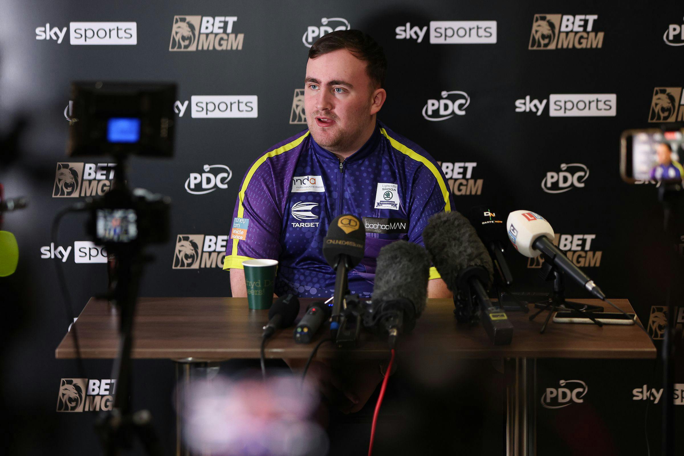 Darts player addressing a press conference 