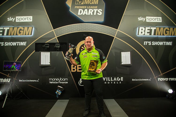 darts player holding trophies