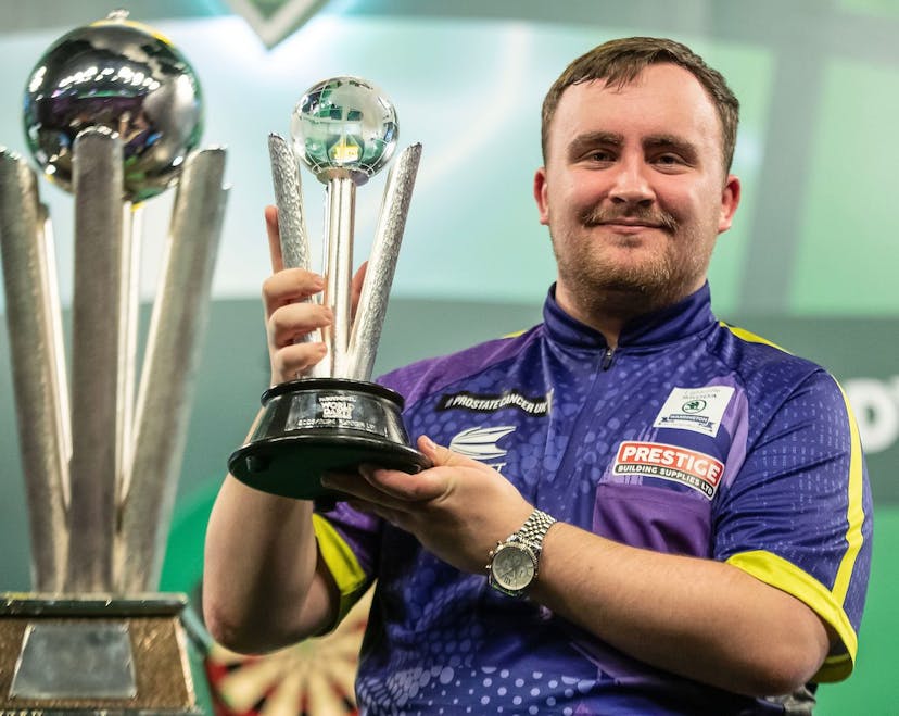 darts player posing with a trophy 
