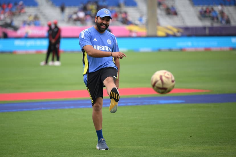 Rohit Sharma of India plays football on the outfield as rain delays the start of play