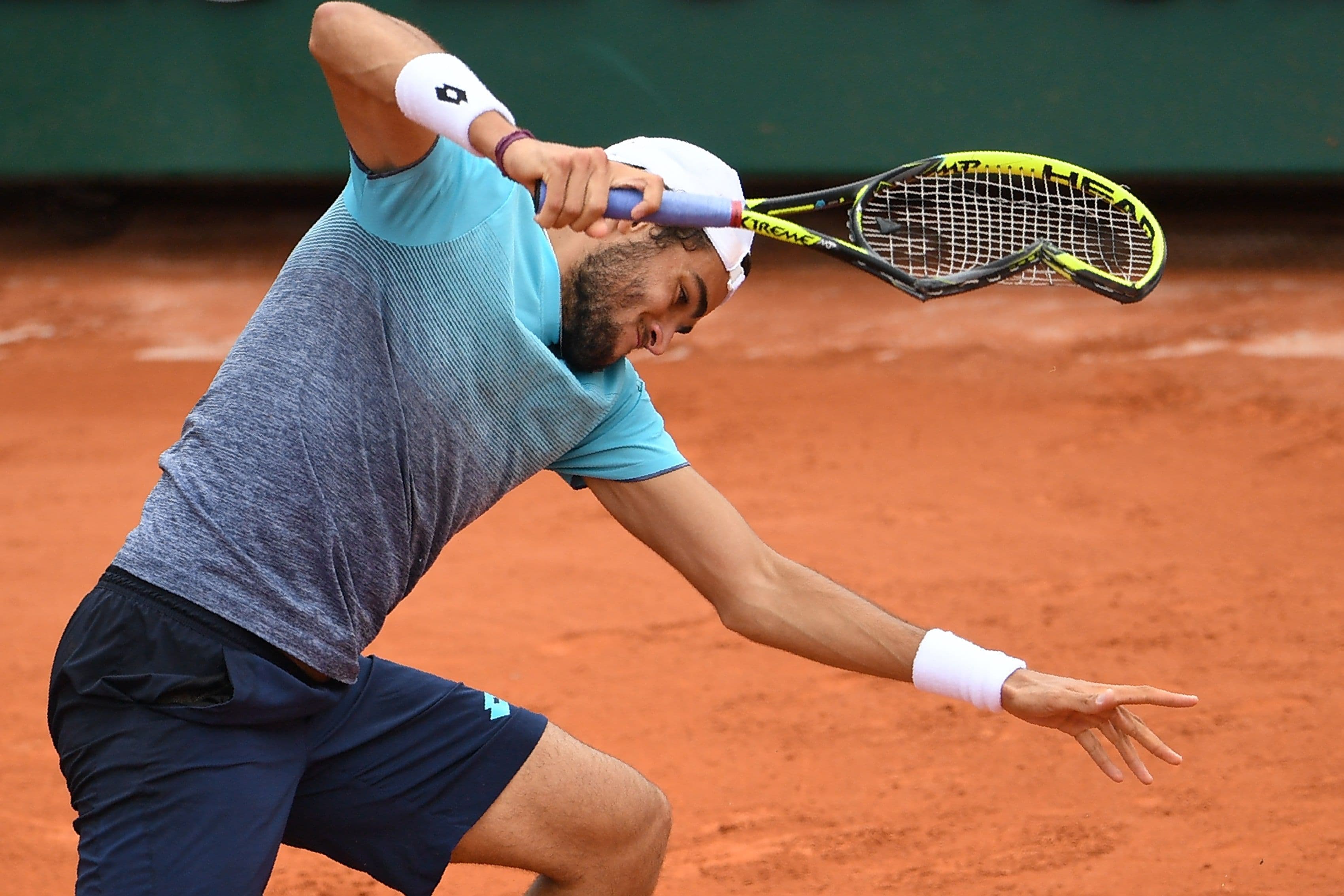 Italy's Matteo Berrettini smashes his racquet into the court