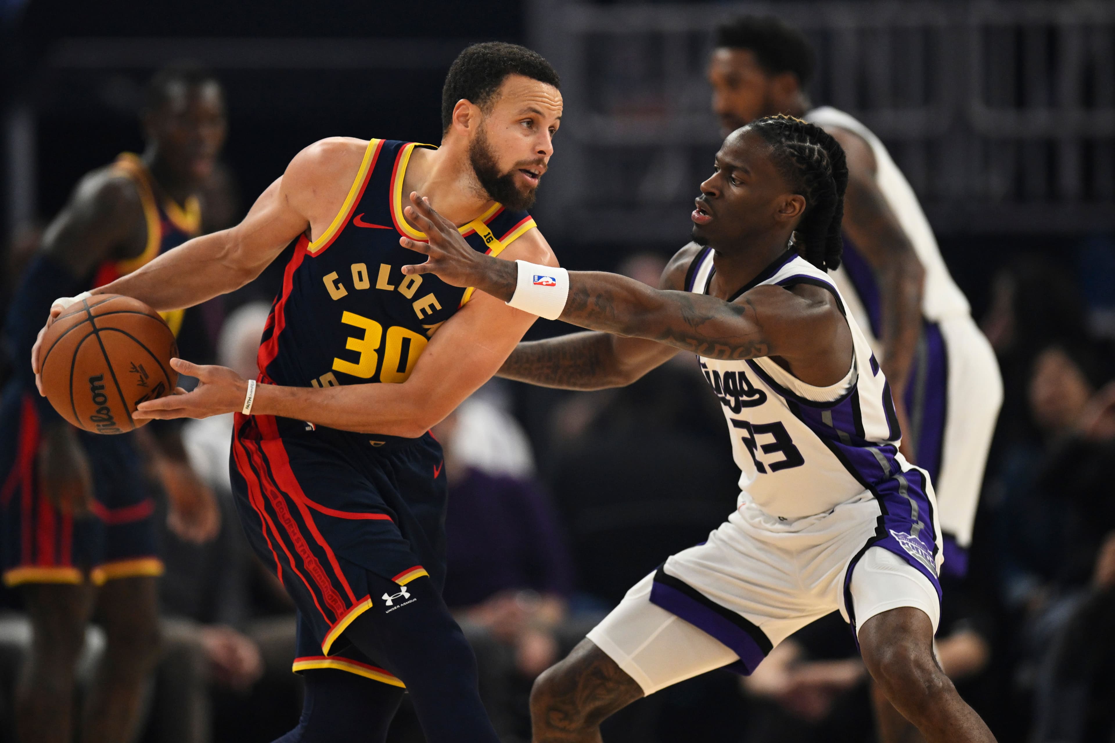 Stephen Curry looks for a pass against Keon Ellis 
