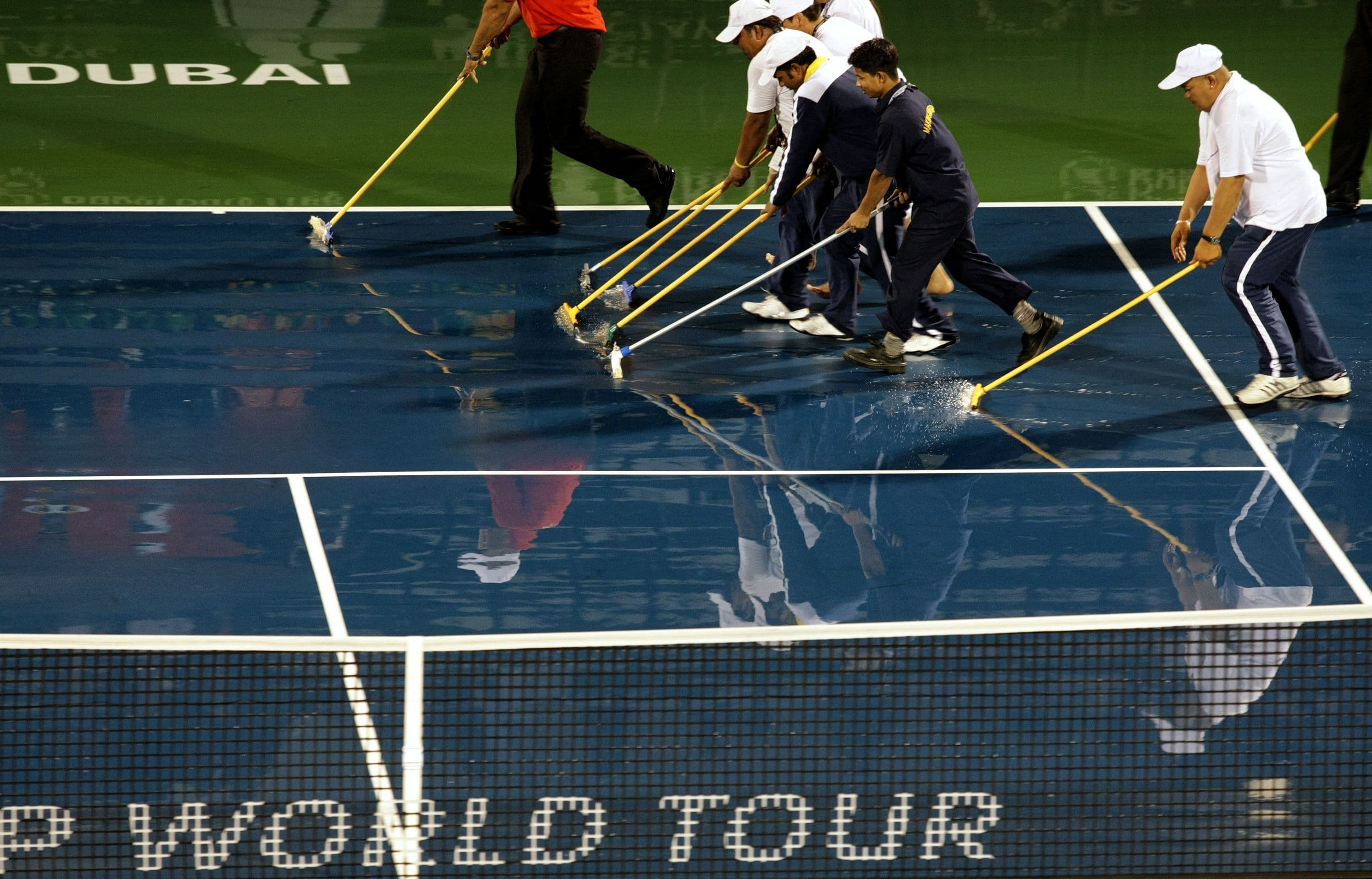 Workers clear water from the court