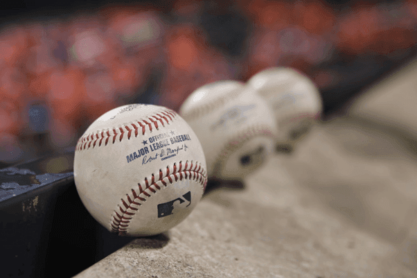 three-white-baseballs-on-gray-textile