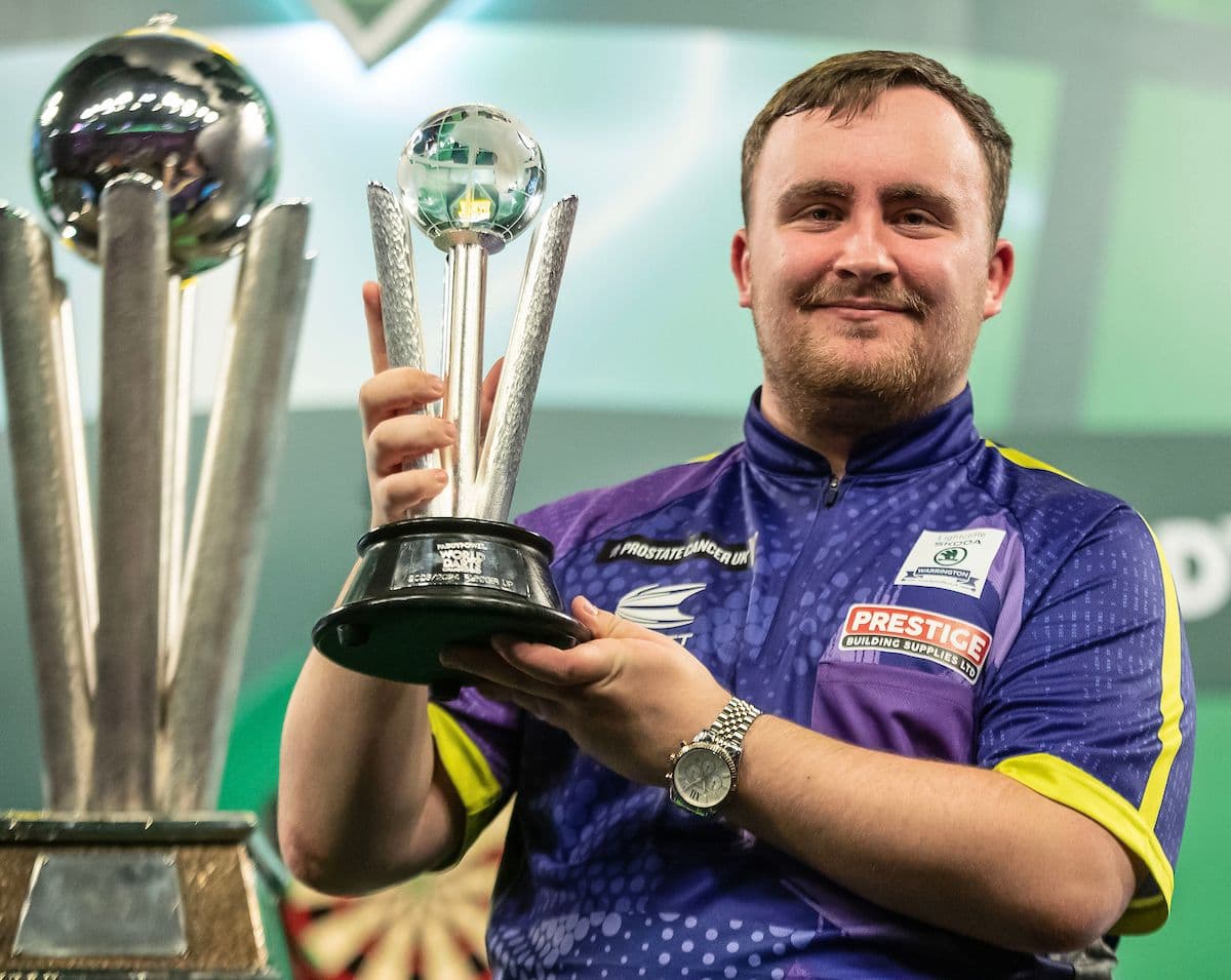 darts player posing with a trophy