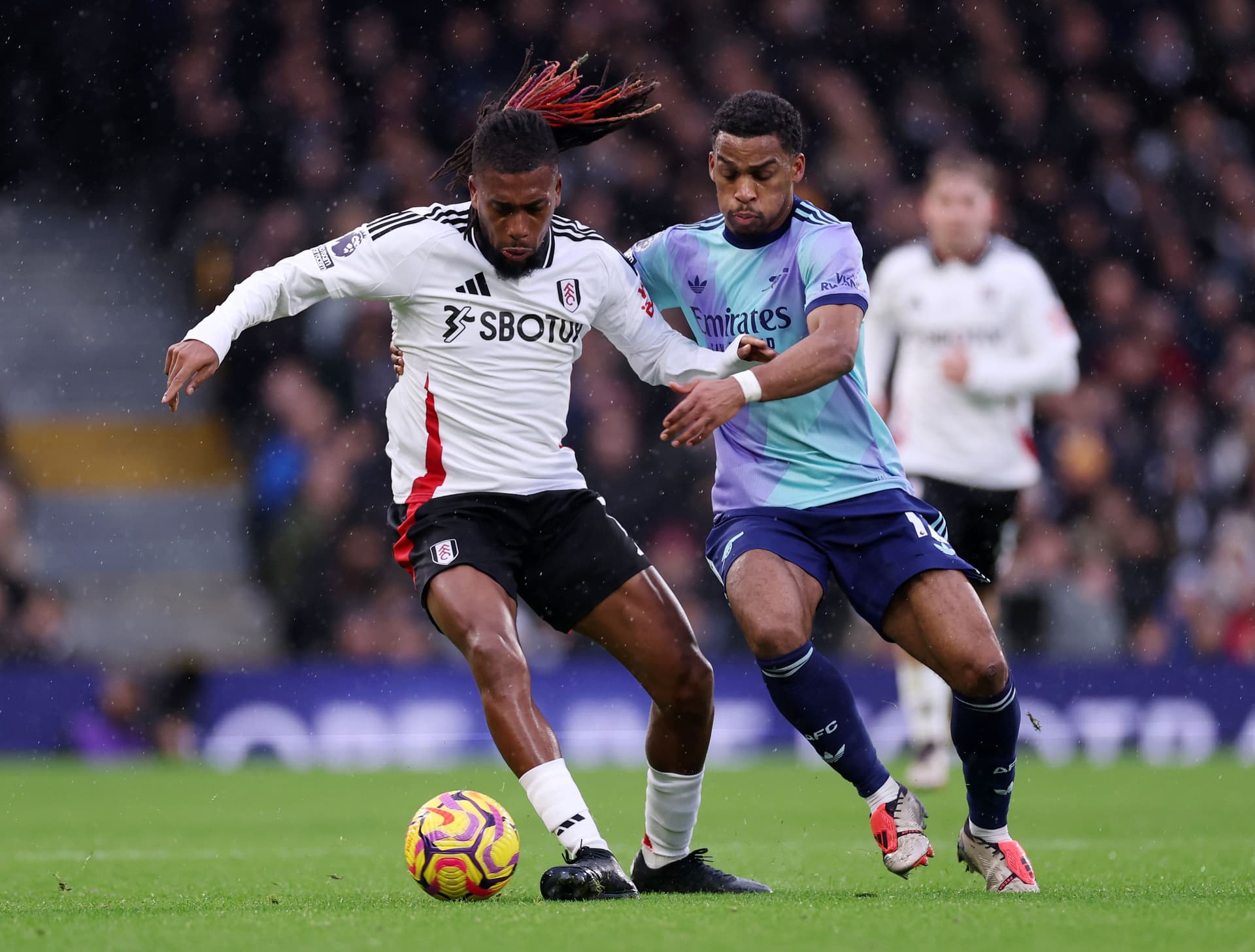 Alex Iwobi of Fulham is challenged by Jurrien Timber