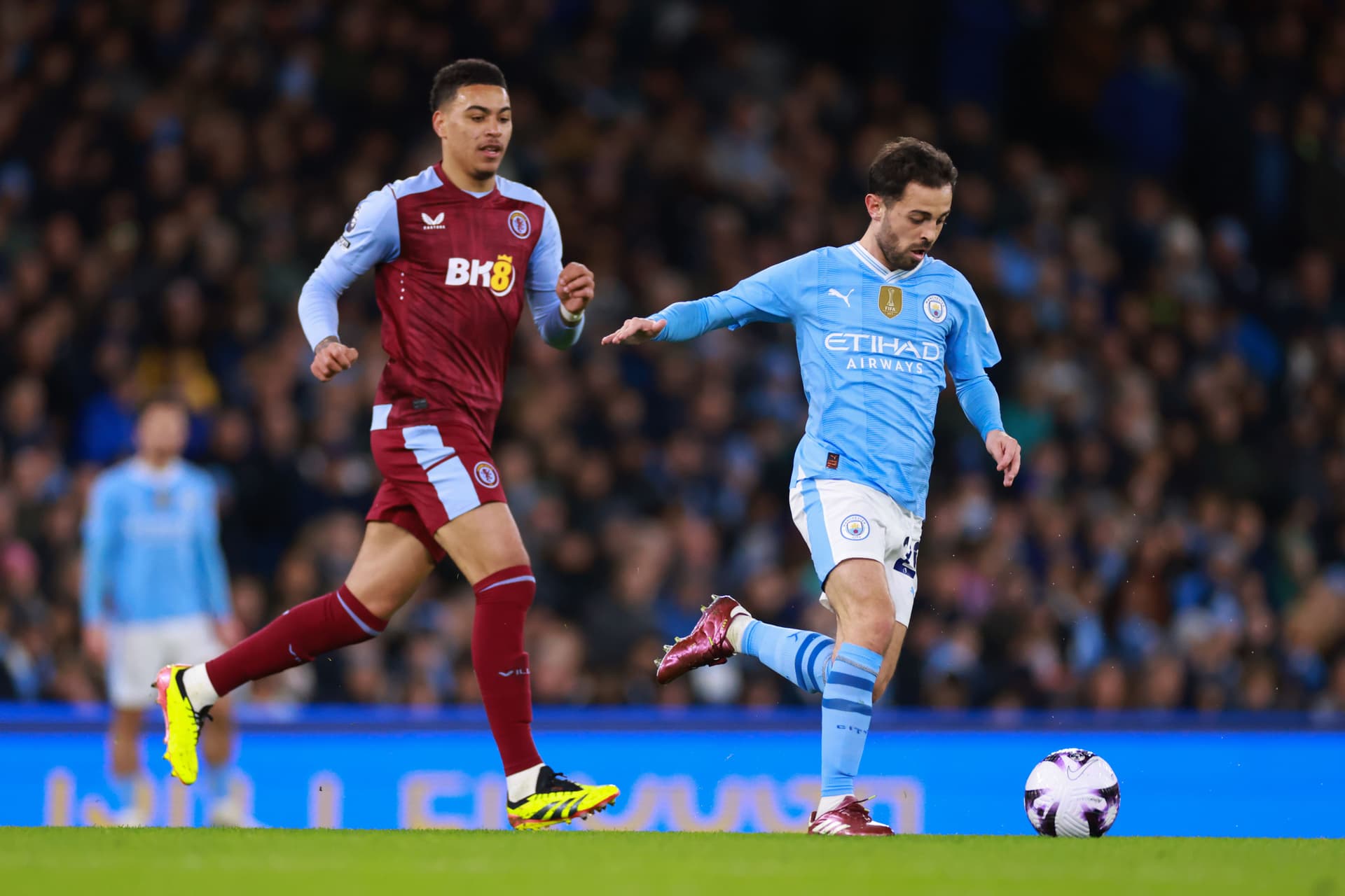 Bernardo Silva of Manchester City in action with Morgan Rogers of Aston Villa