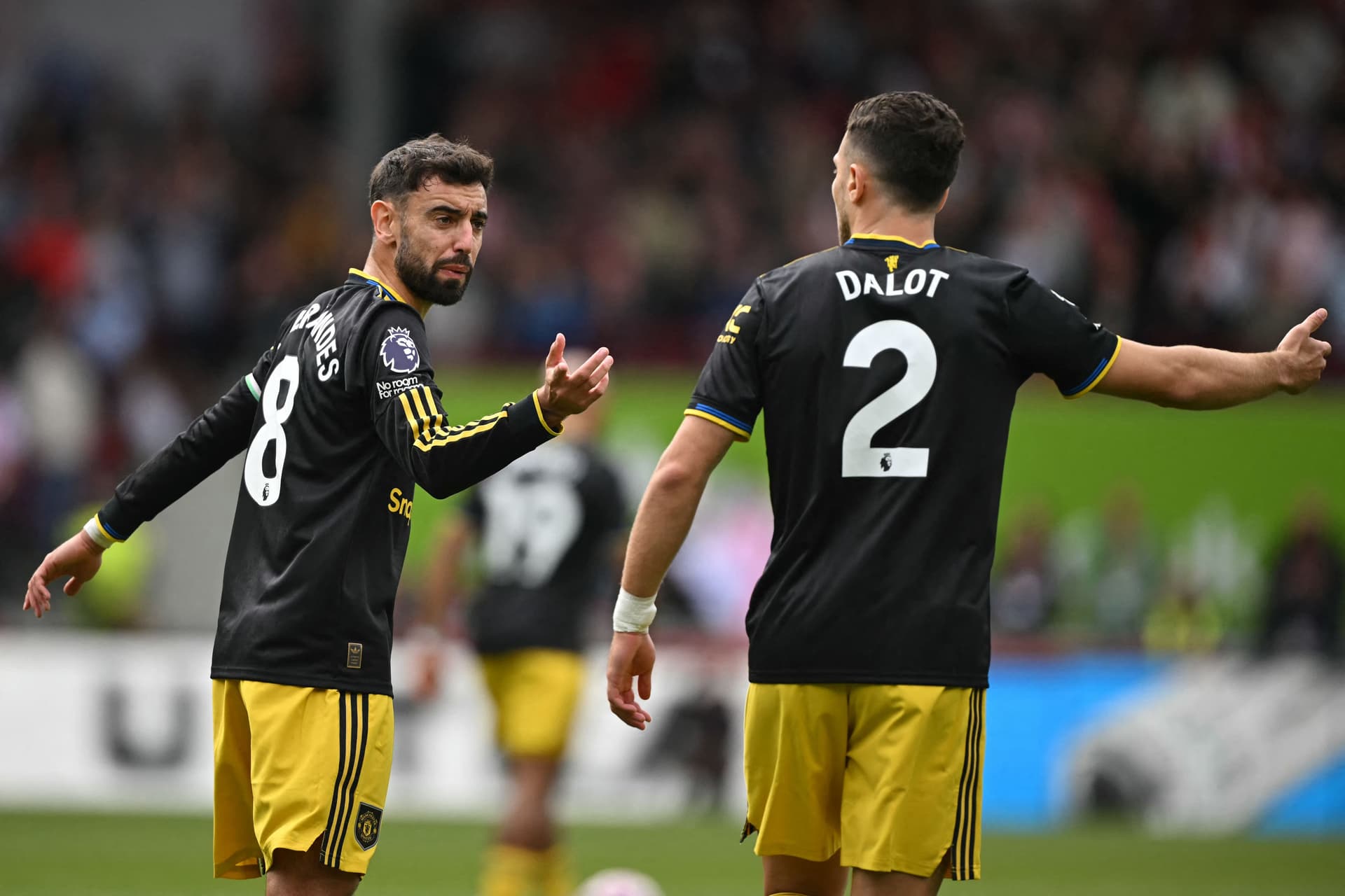Bruno Fernandes (L) gestures to Manchester United's Portuguese defender #02 Diogo Dalot (R)