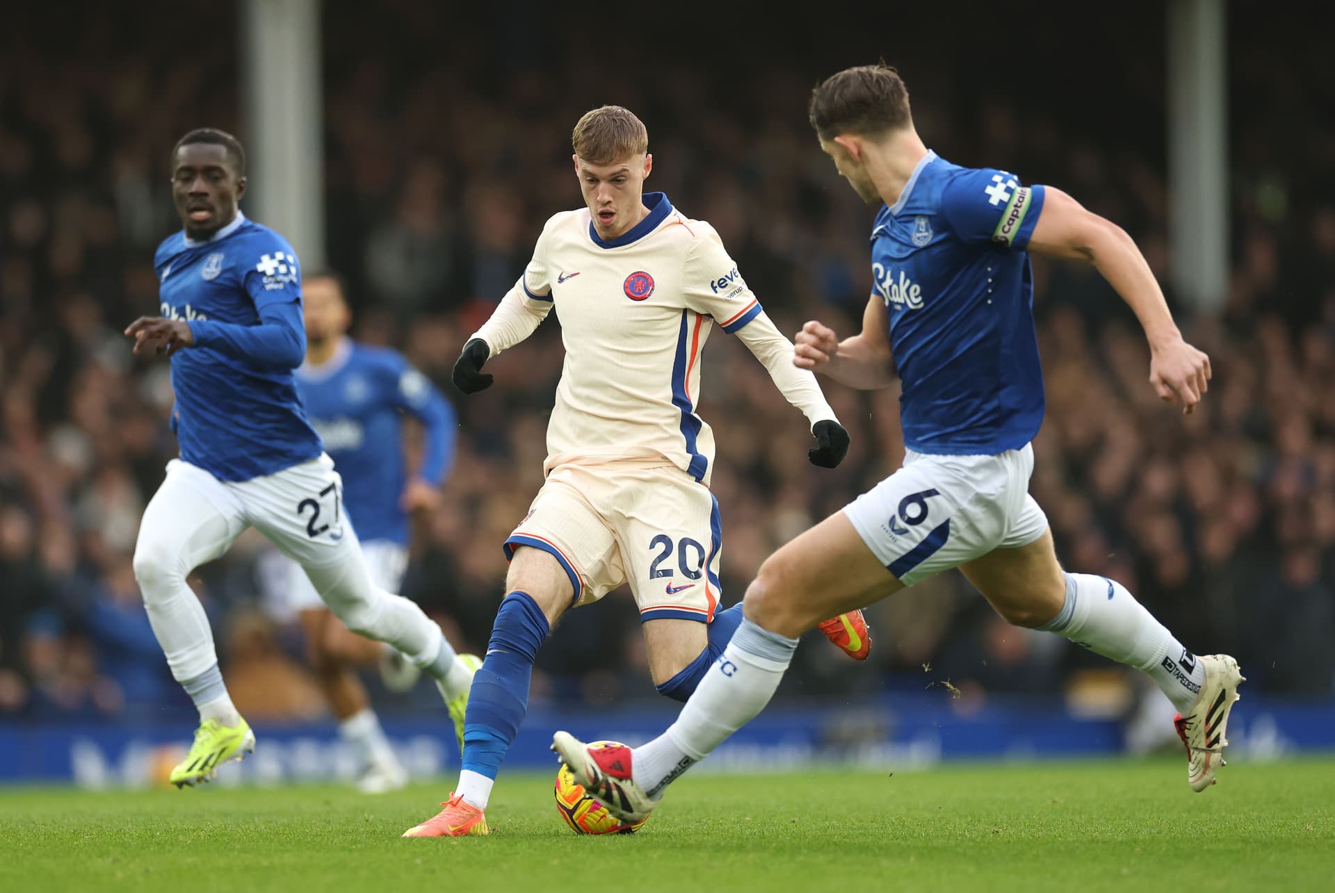 Cole Palmer runs with the ball whilst under pressure from Idrissa Gueye and James Tarkowski