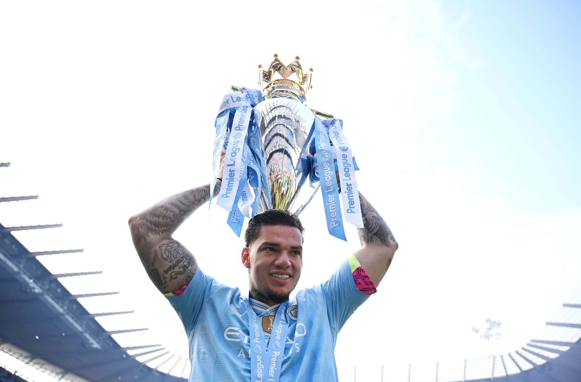 Ederson celebrates with the Premier League Trophy