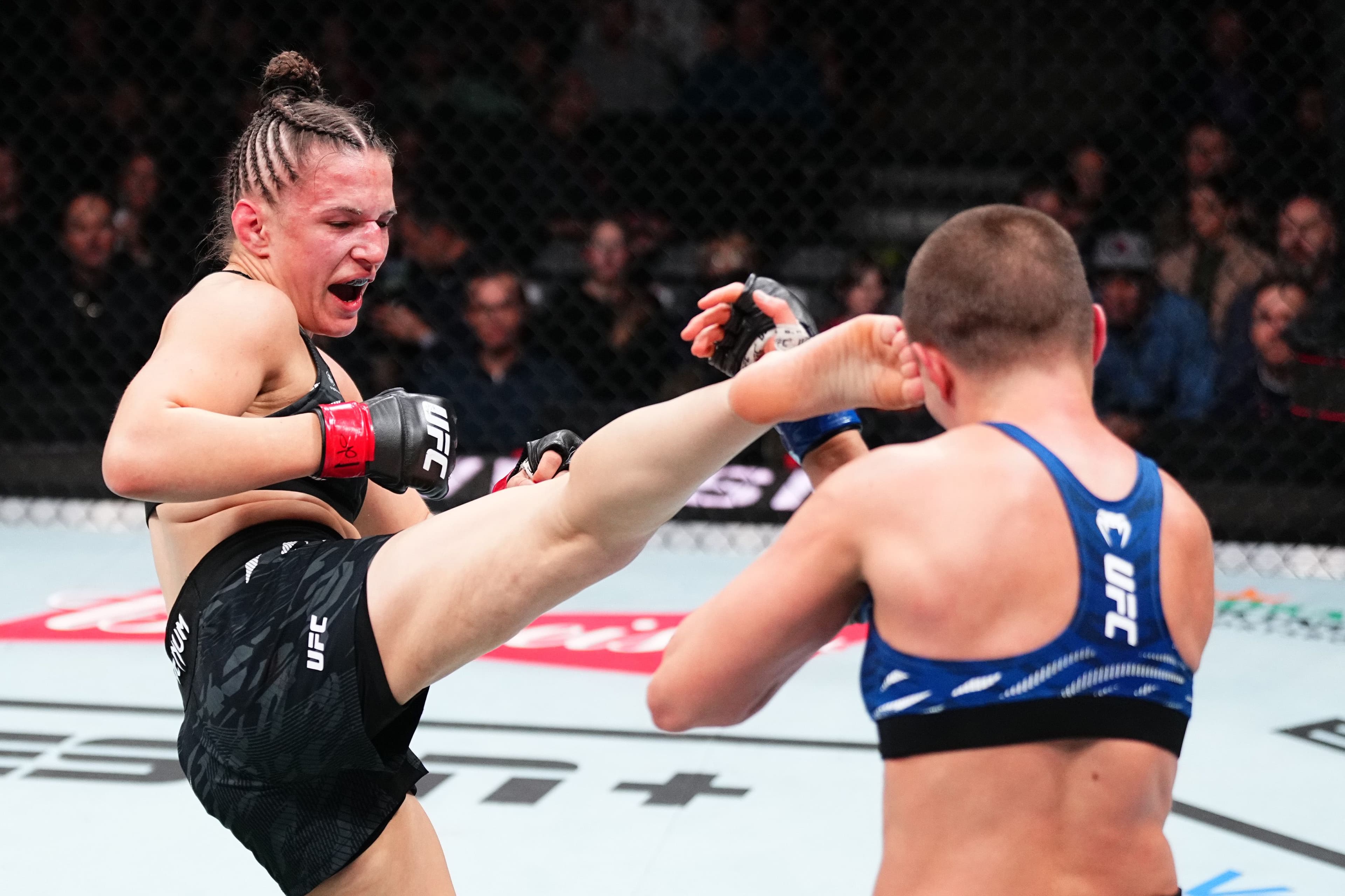 Erin Blanchfield kicks Rose Namajunas in a flyweight fight.jpg