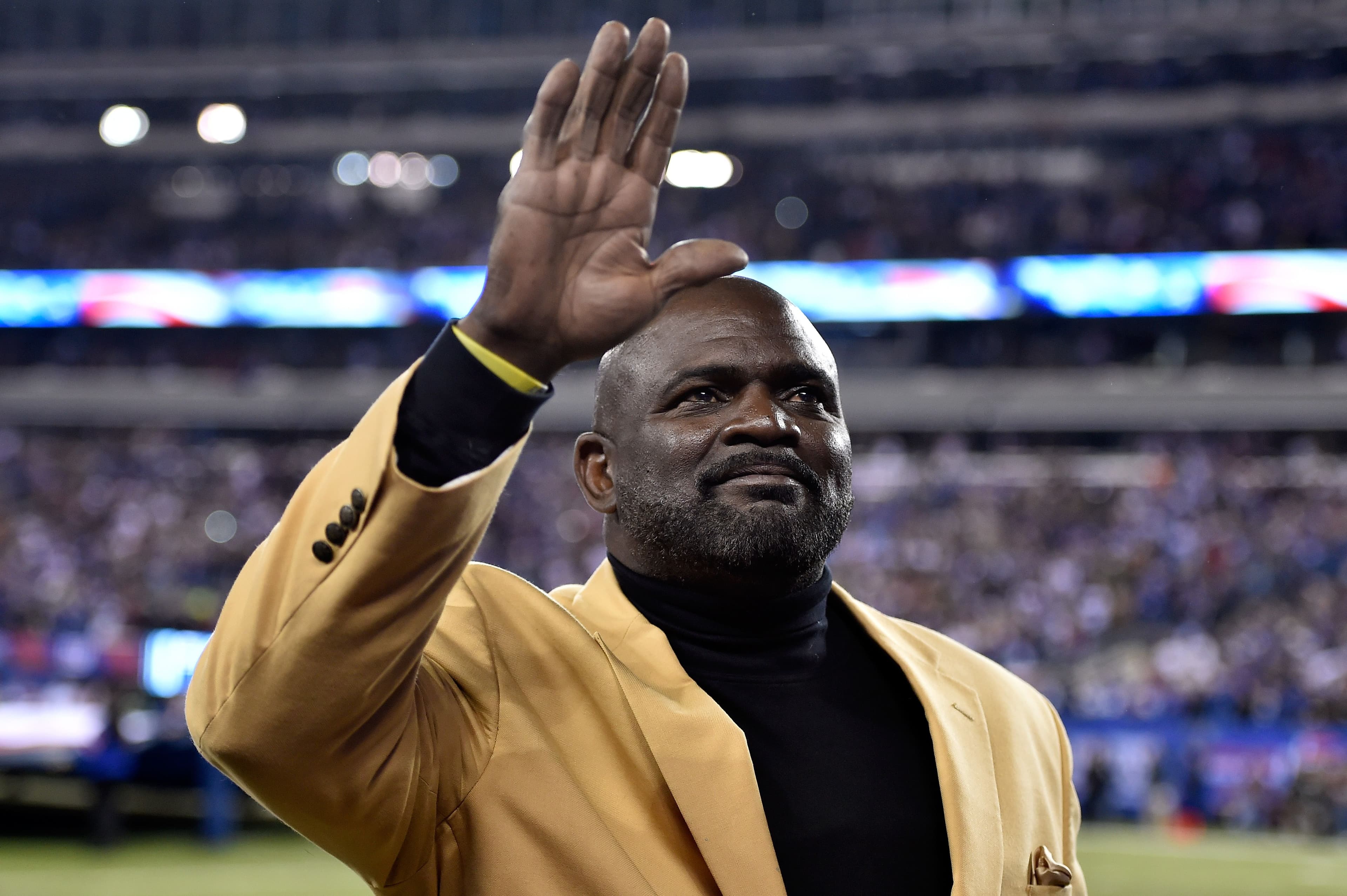 Former New York Giants player Lawrence Taylor waves to the crowd