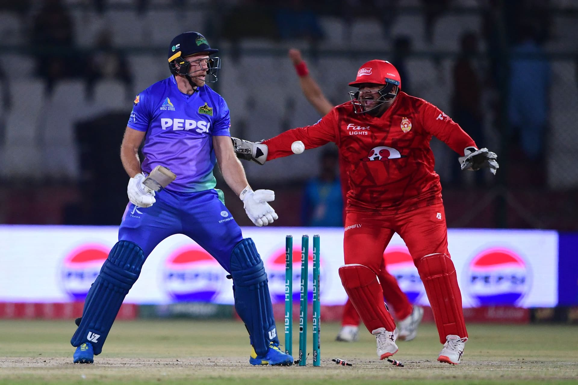 Islamabad United's wicket keeper Azam Khan (R) celebrates the wicket of Multan Sultans' David Willey