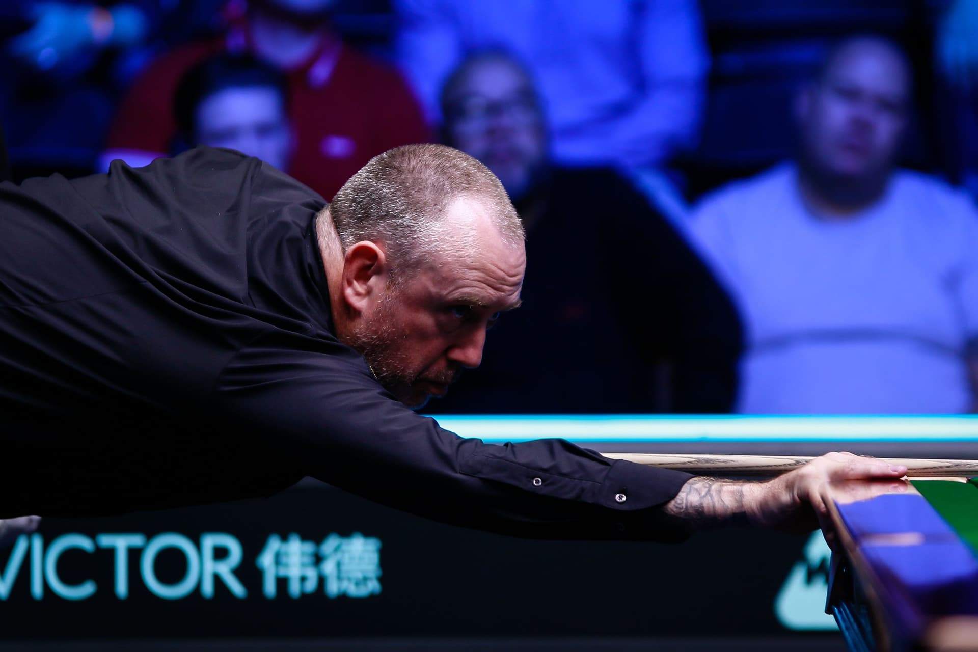 Mark Williams of Wales plays a shot in the first round match against Ben Woollaston of England