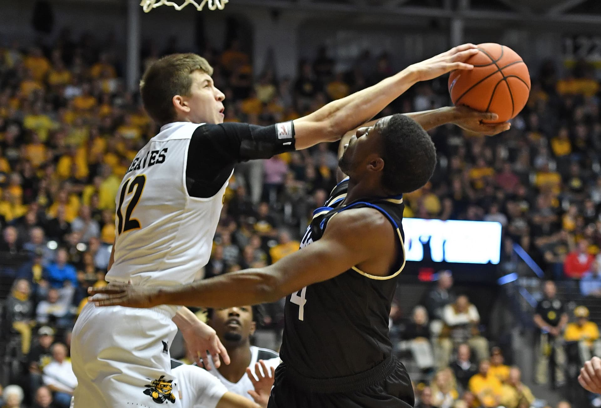 Guard Austin Reaves #12 of the Wichita State Shockers blocks the shot attempt of forward Tarekeyi Edogi #14