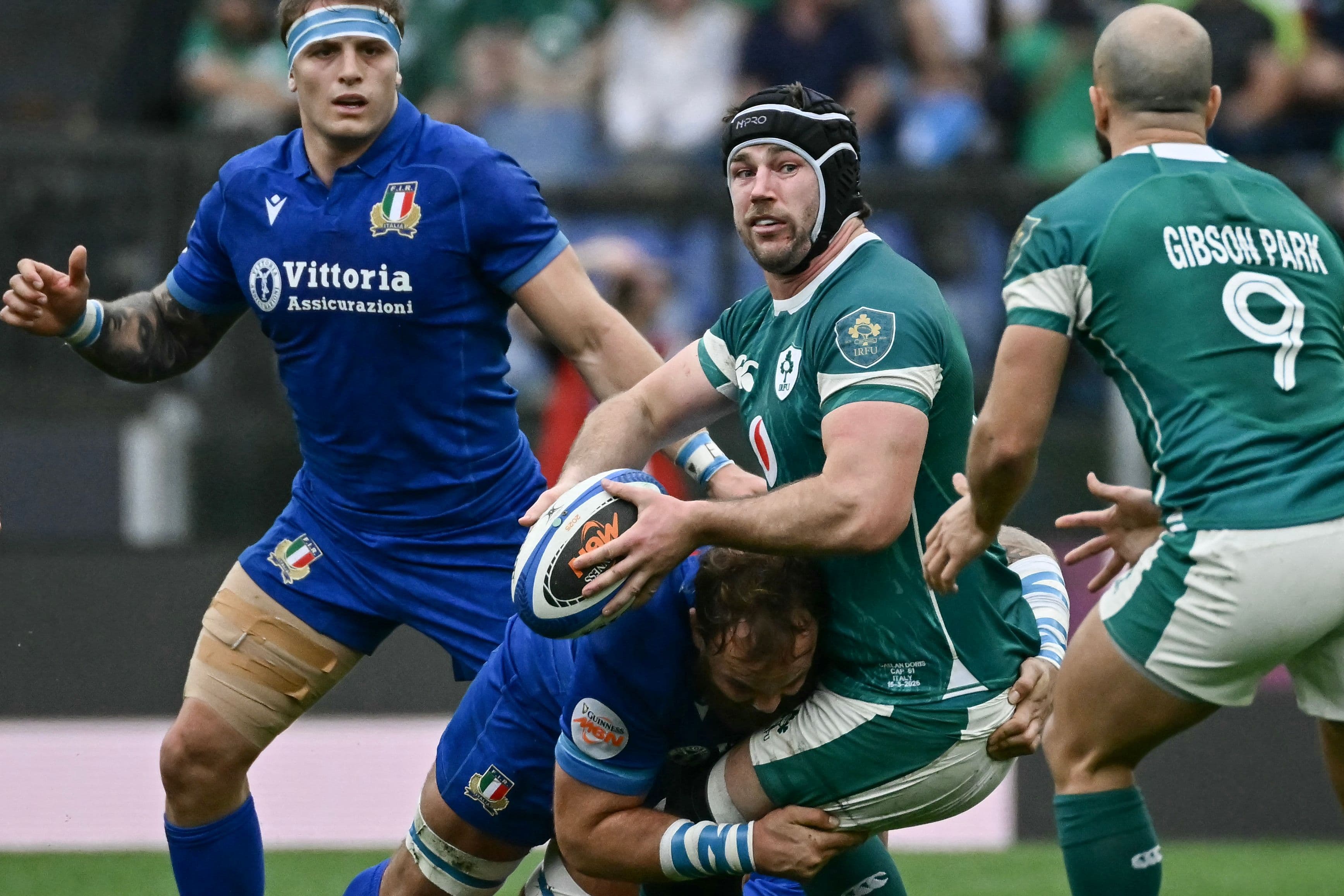 Ireland's number 8 Caelan Doris (C) is tackled by Italy's lock Niccolo Cannone