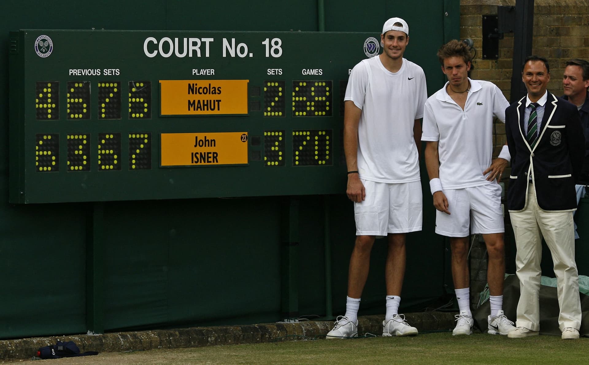 John Isner of the US (L), France's Nicolas Mahut (2nd L), and chair umpire Mohamed Lahyani (2nd R)