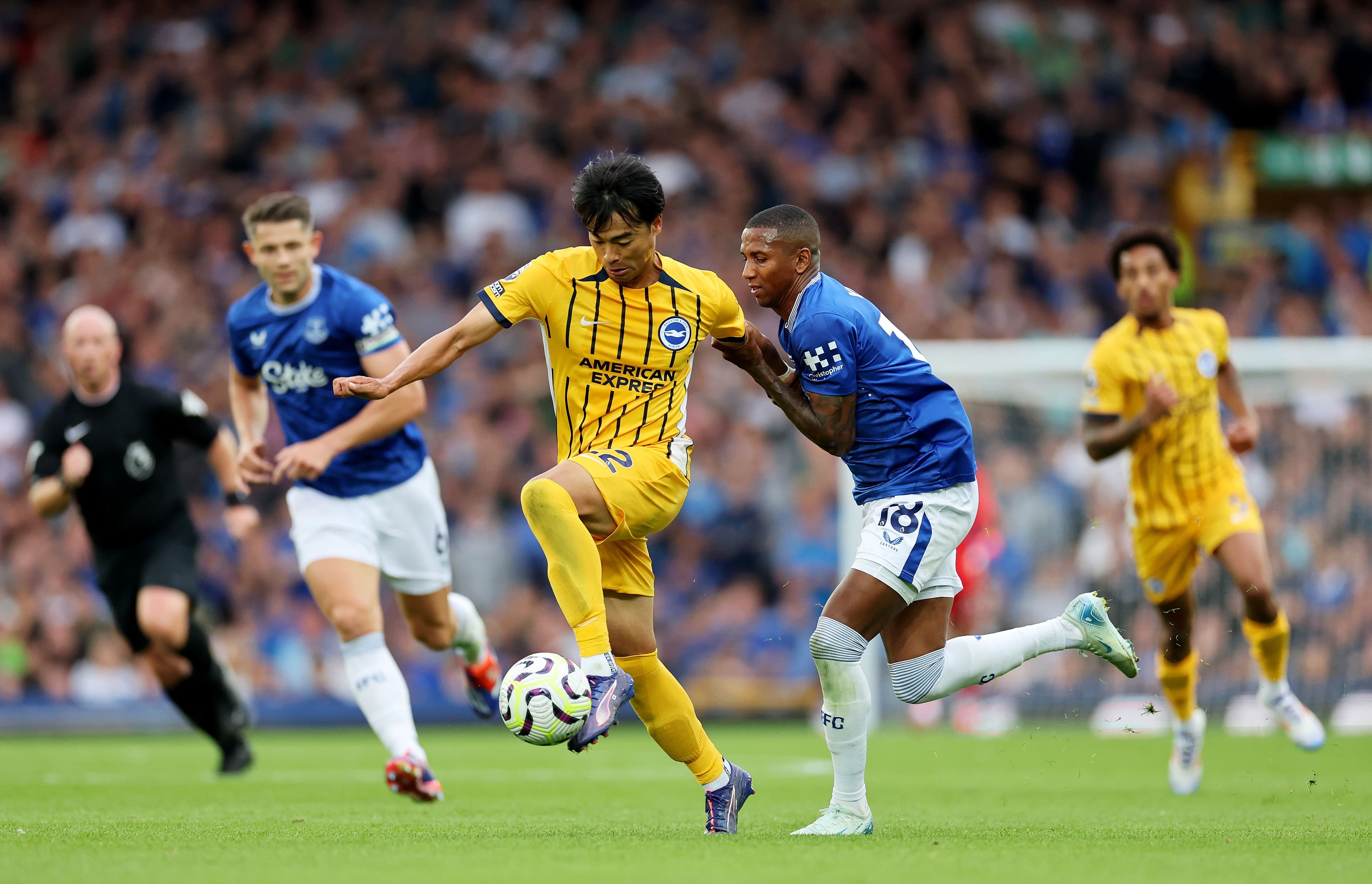 Kaoru Mitoma of Brighton & Hove Albion is fouled by Ashley Young of Everton