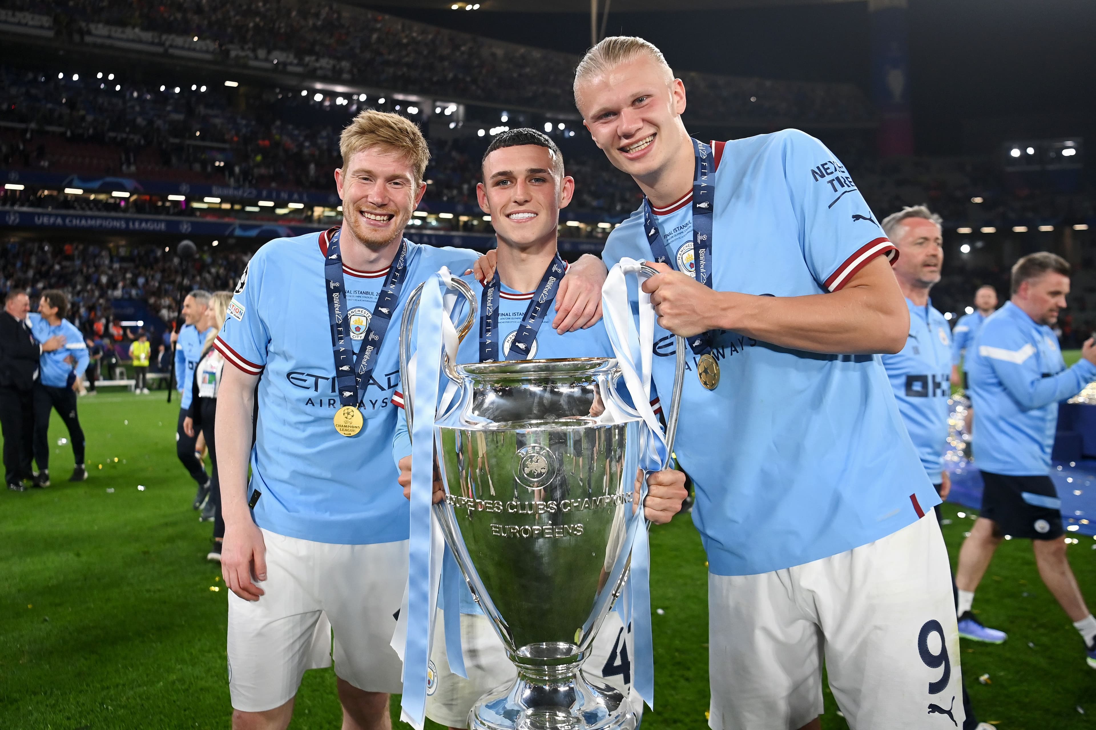 Kevin De Bruyne, Phil Foden and Erling Haaland of Manchester City pose for a pose for a photograph with the UEFA Champions League trophy