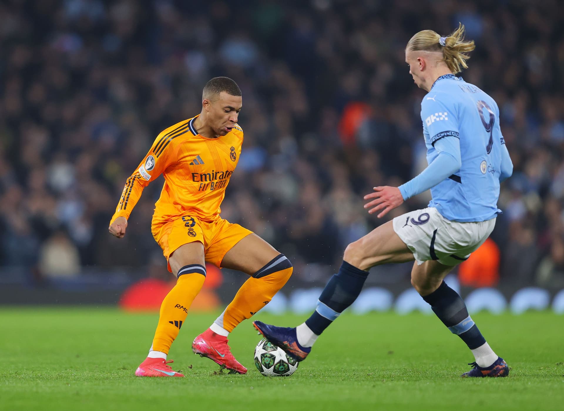 Kylian Mbappe of Real Madrid is challenged by Erling Haland of Manchester City