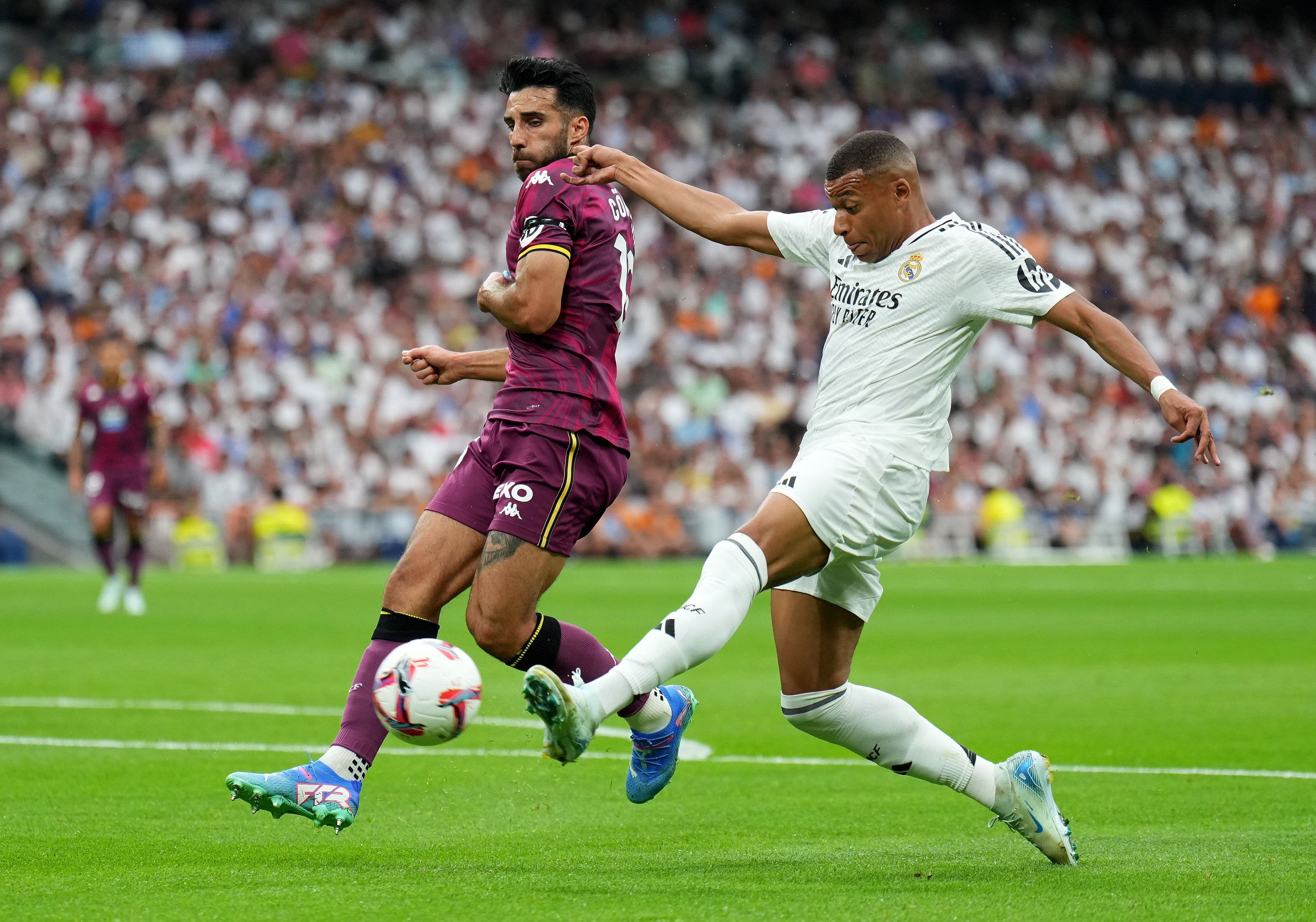 Kylian Mbappe shoots whilst under pressure from Eray Cuemart