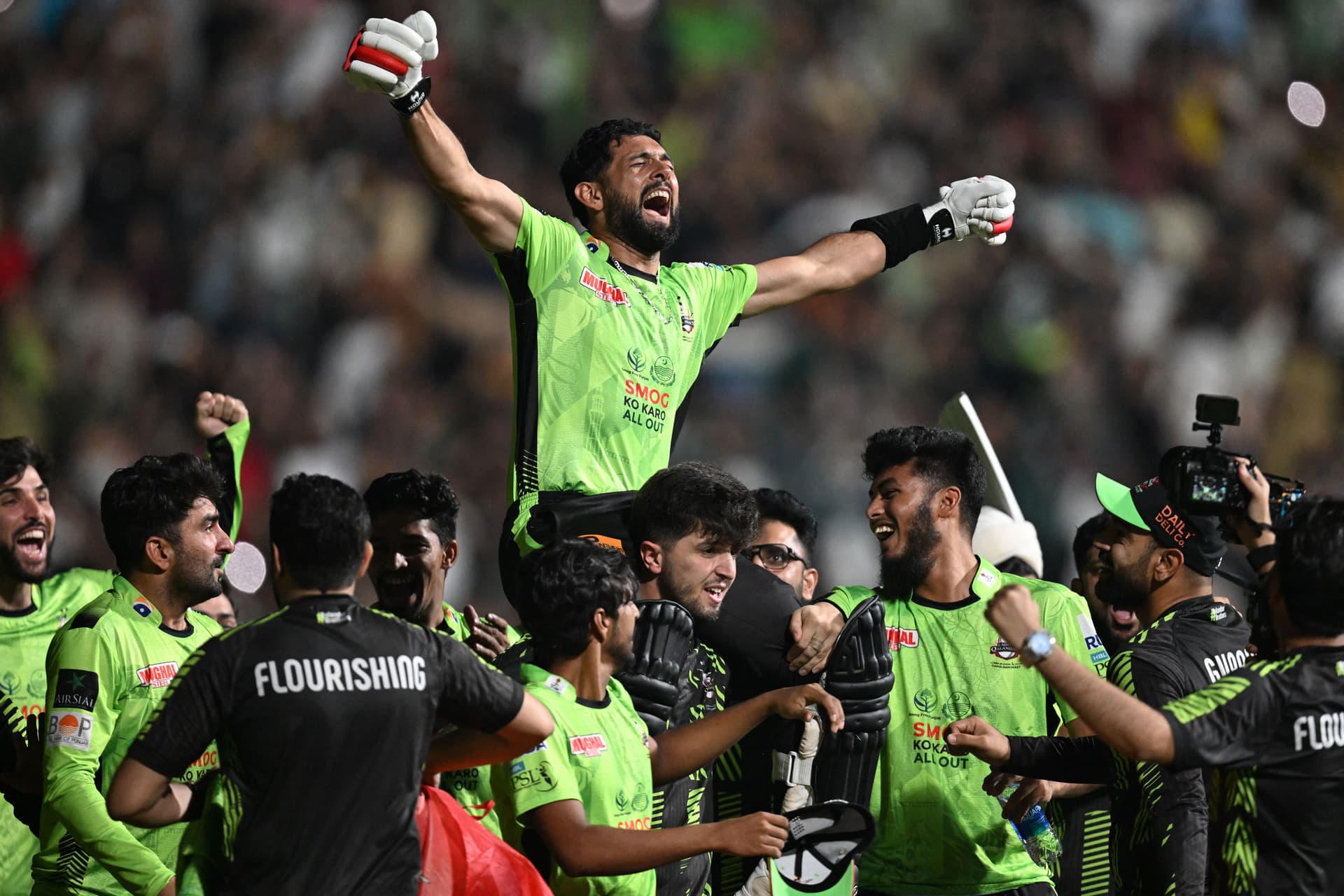 Lahore Qalanders' players carry teammate Sikandar Raza as they celebrate after their victory in the Pakistan Super League