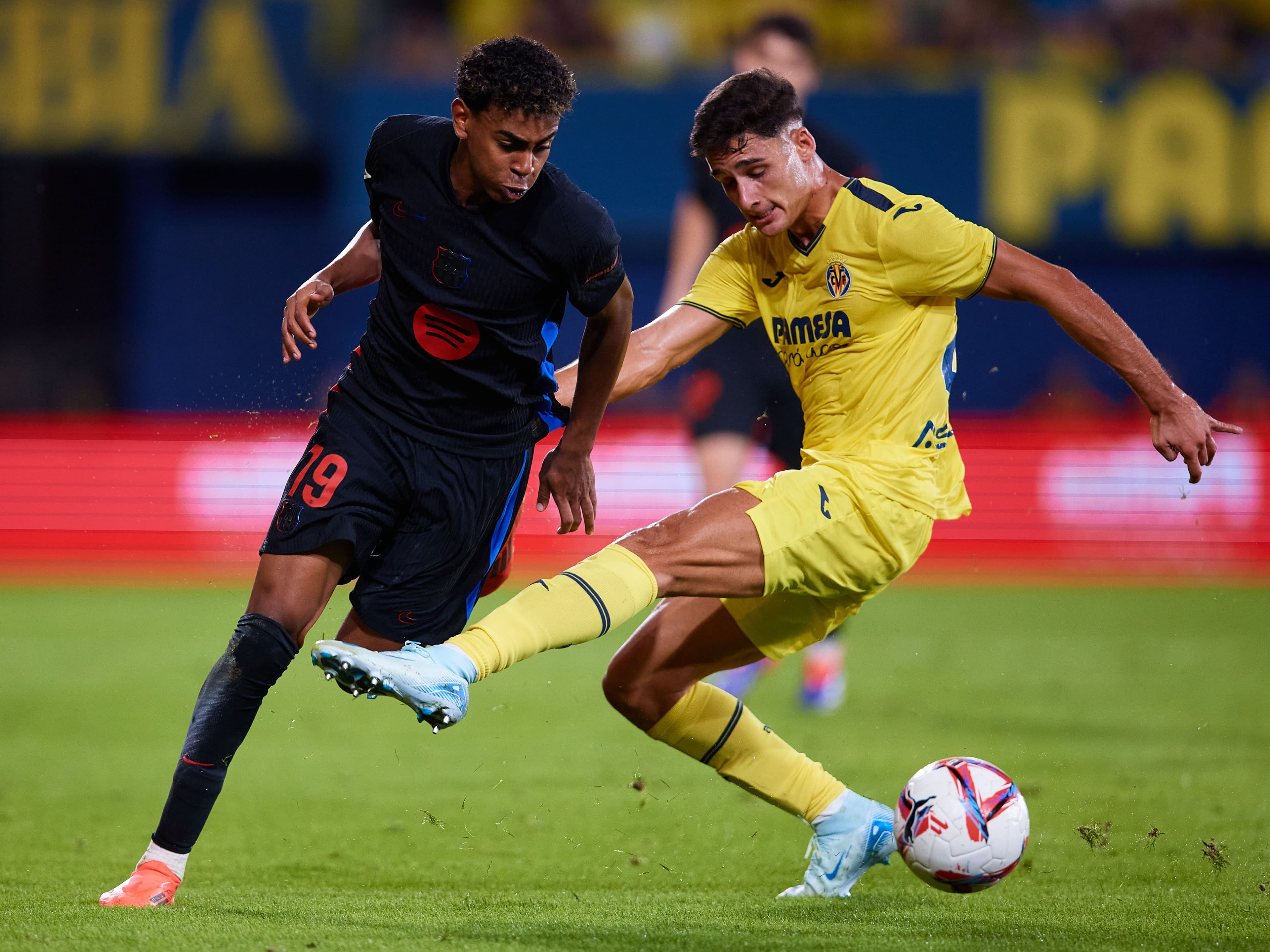 Lamine Yamal of FC Barcelona competes for the ball with Sergi Cardona of Villarreal CF