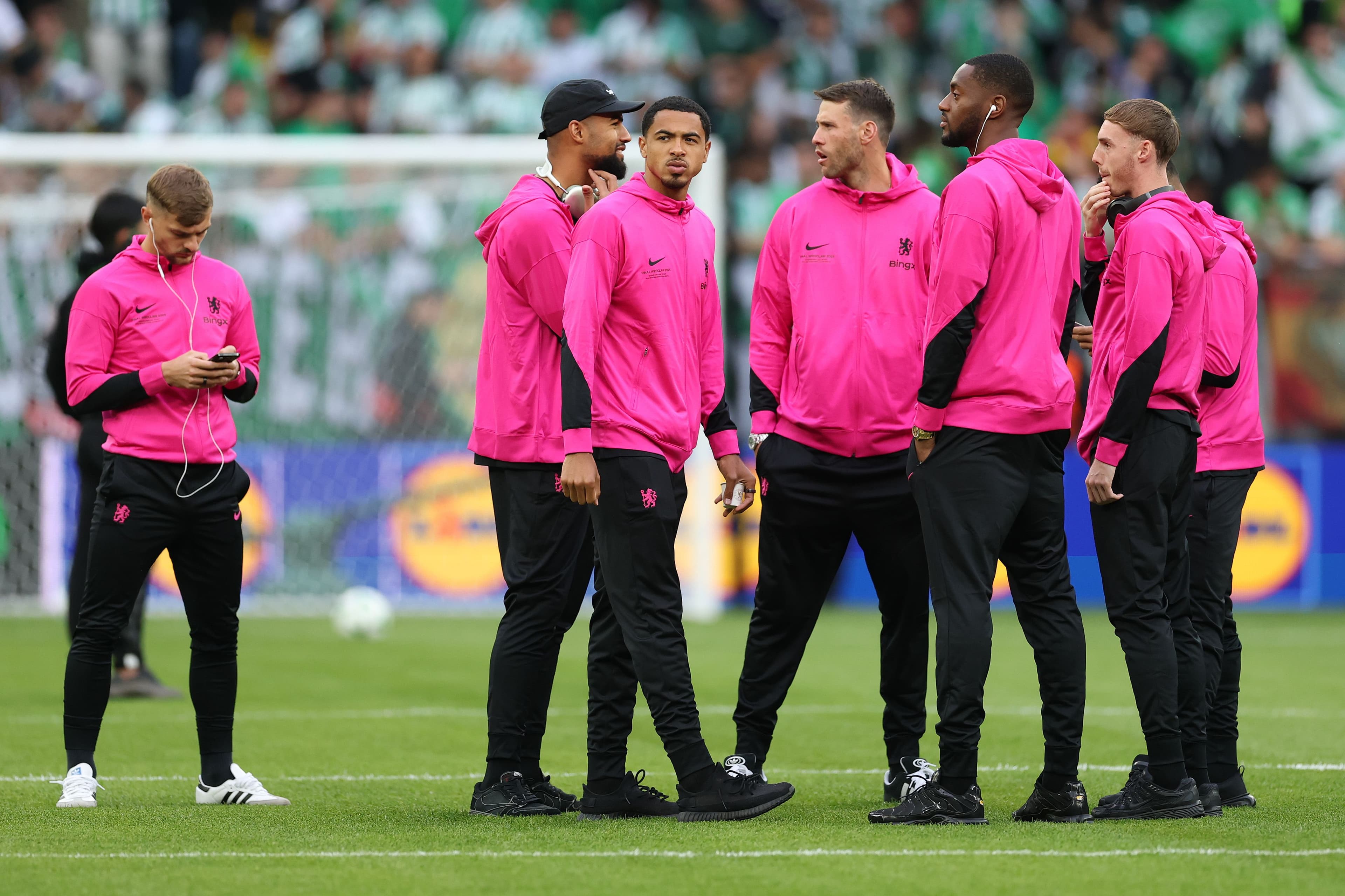 Levi Colwill of Chelsea inspects the pitch with teammates Robert Sanchez, Tosin Adarabioyo and Cole Palmer