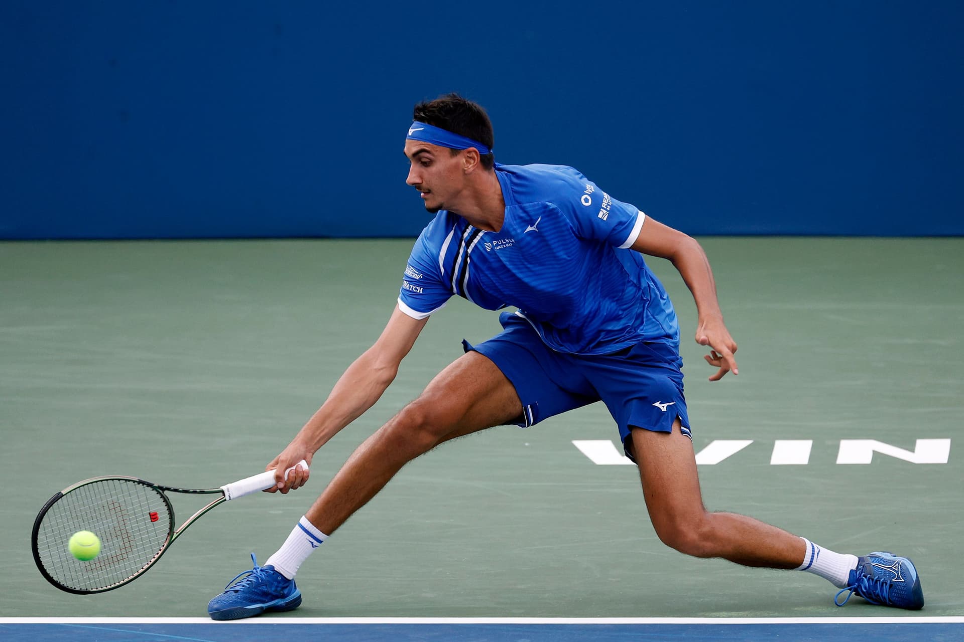 Lorenzo Sonego of Italy returns a shot from Maxime Cressy