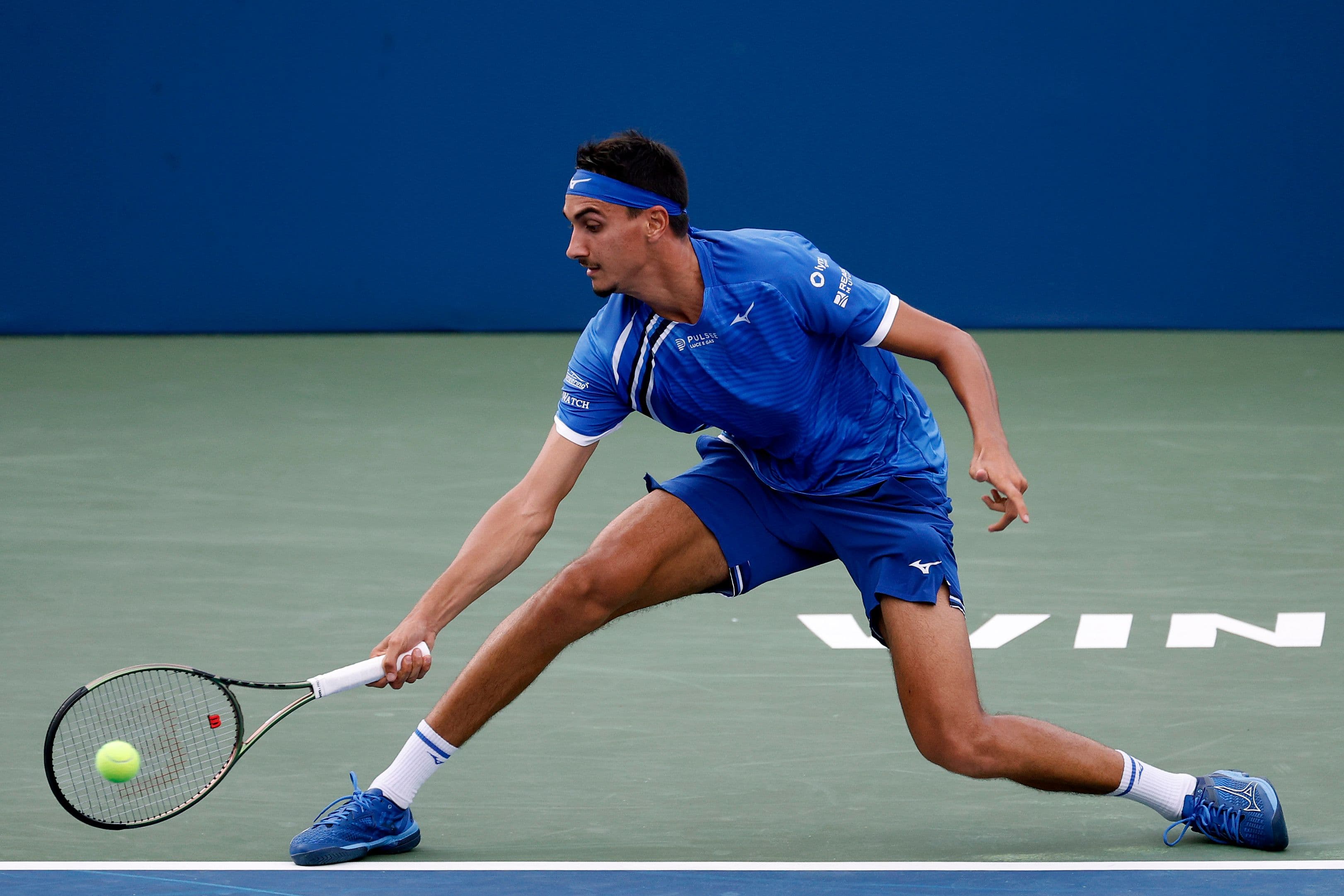 Lorenzo Sonego of Italy returns a shot from Maxime Cressy