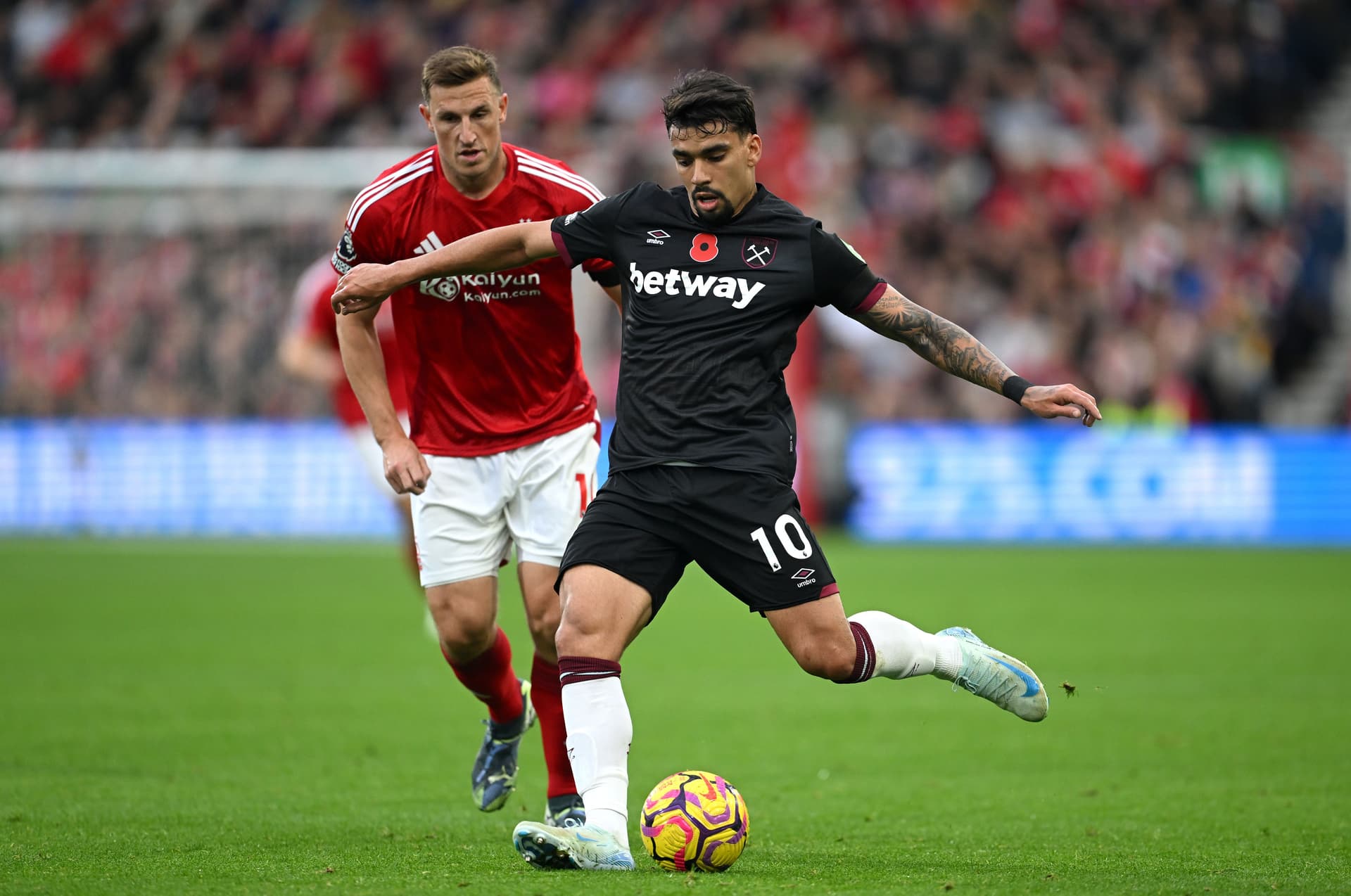 Lucas Paqueta runs with the ball whilst under pressure from Chris Wood