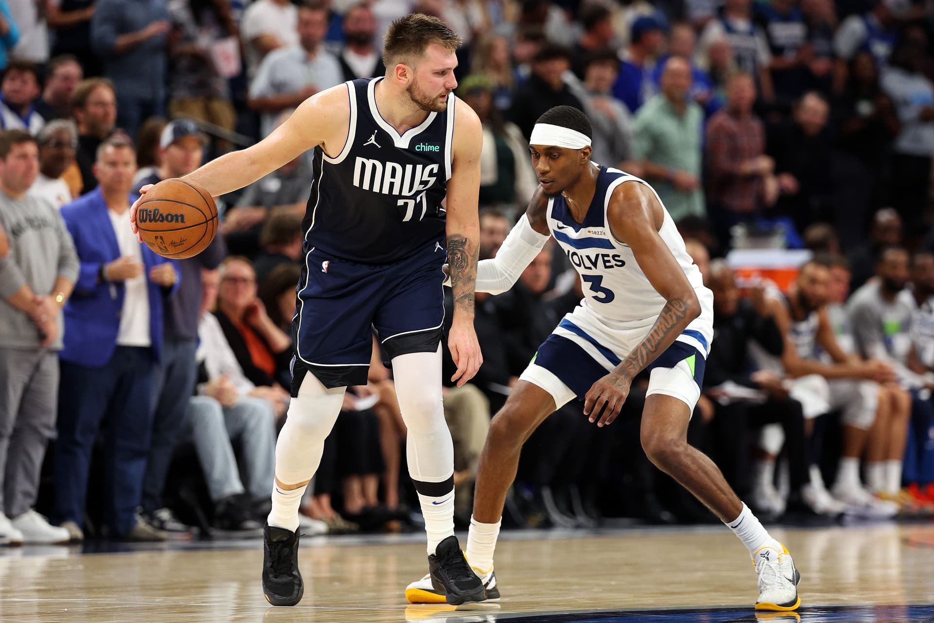 Luka Doncic dribbles the ball against Jaden McDaniels