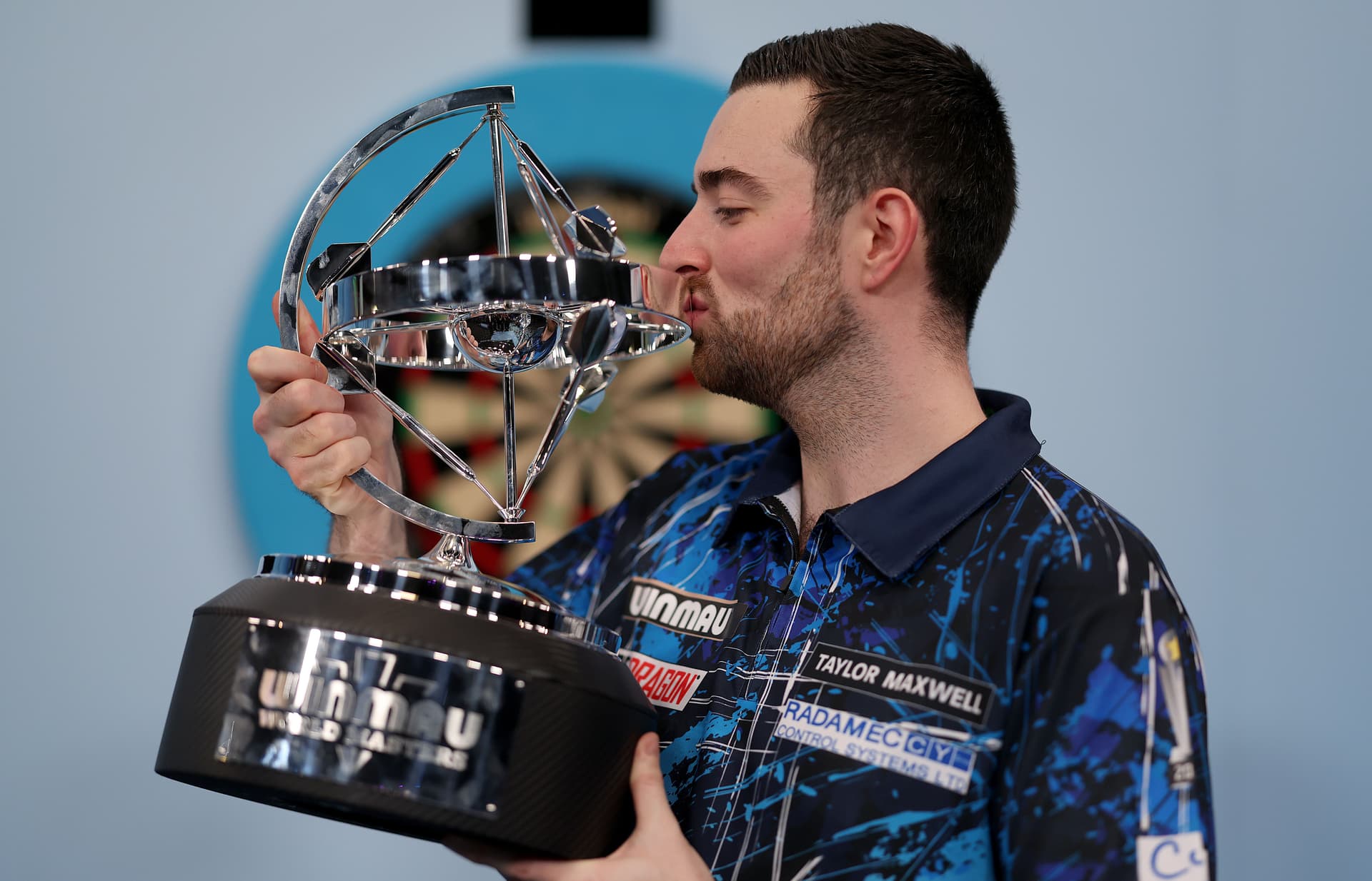 Luke Humphries of England kisses the trophy