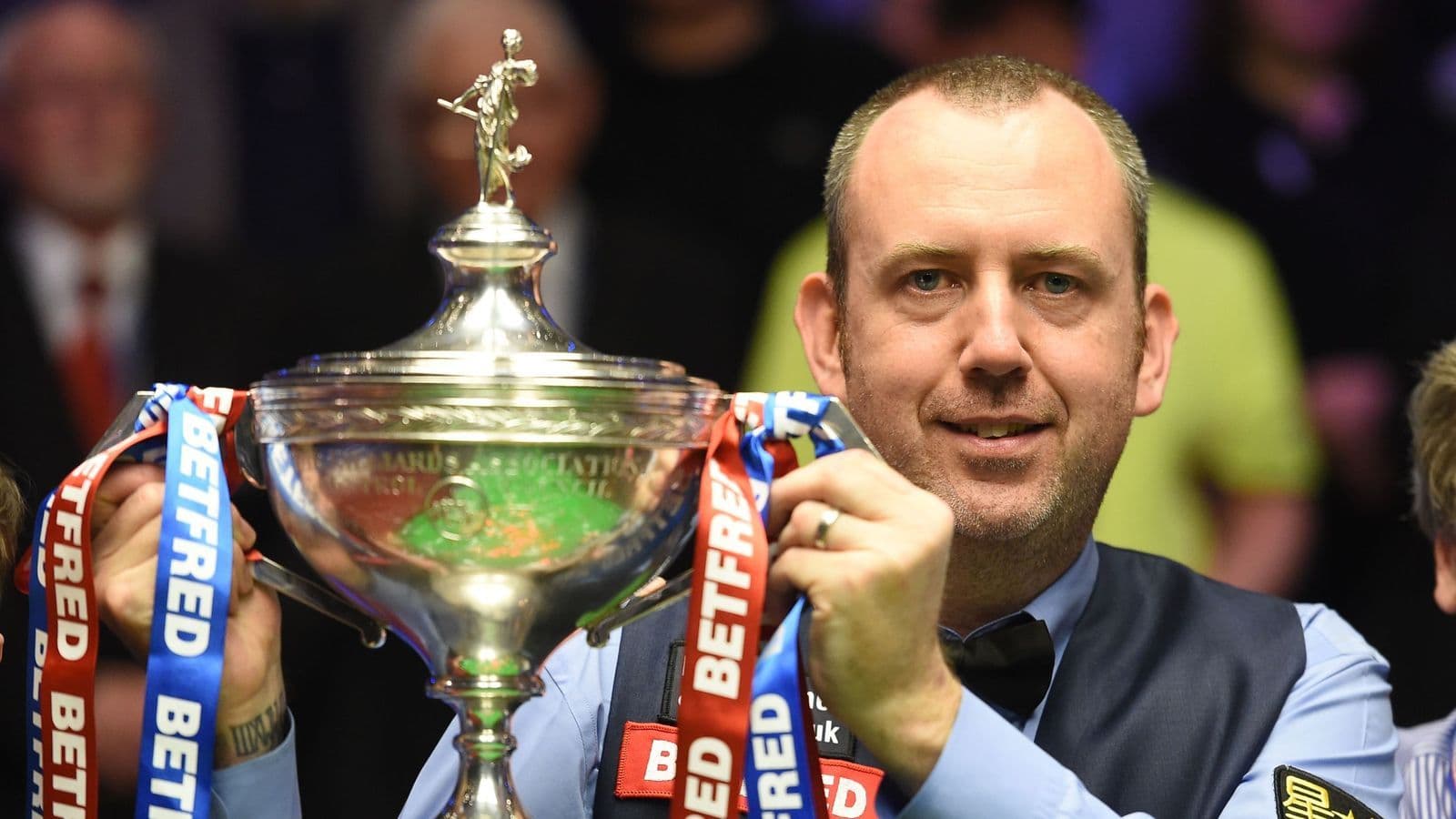 Snooker player Mark Williams holding a championship trophy