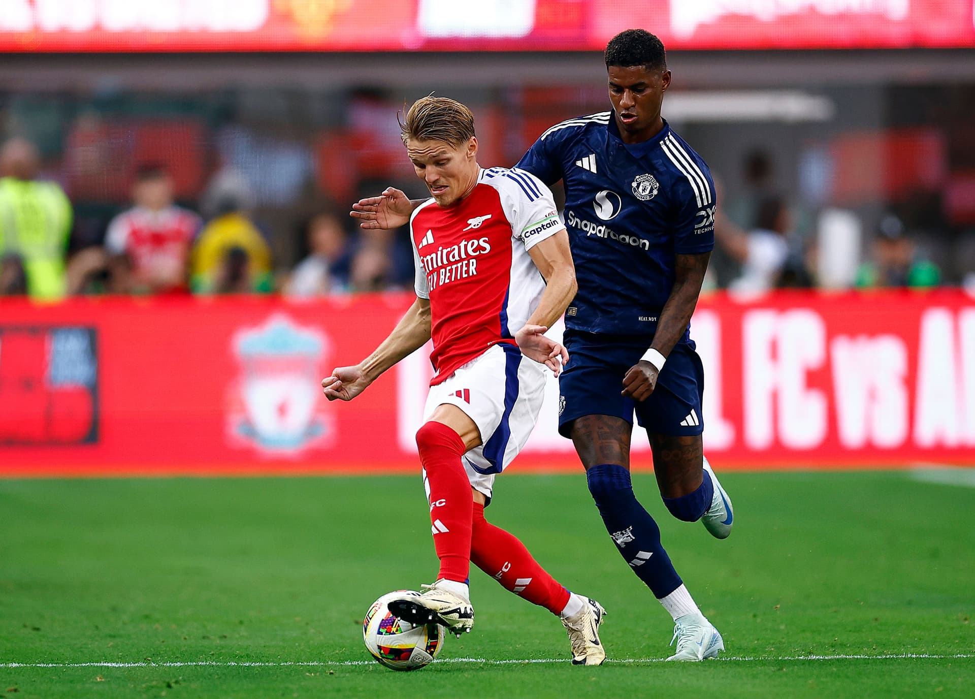 Martin Odegaard controls the ball against Marcus Rashford