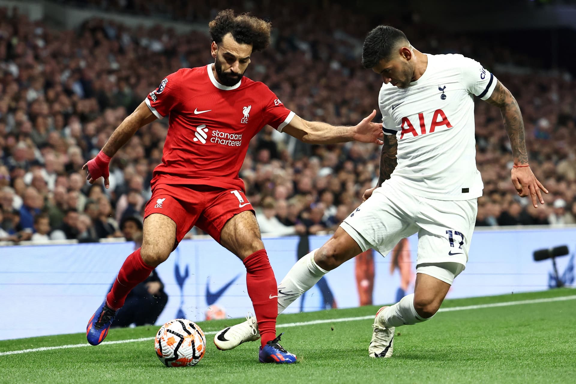Mohamed Salah fights for the ball with Tottenham Hotspur's Argentinian defender Cristian Romero