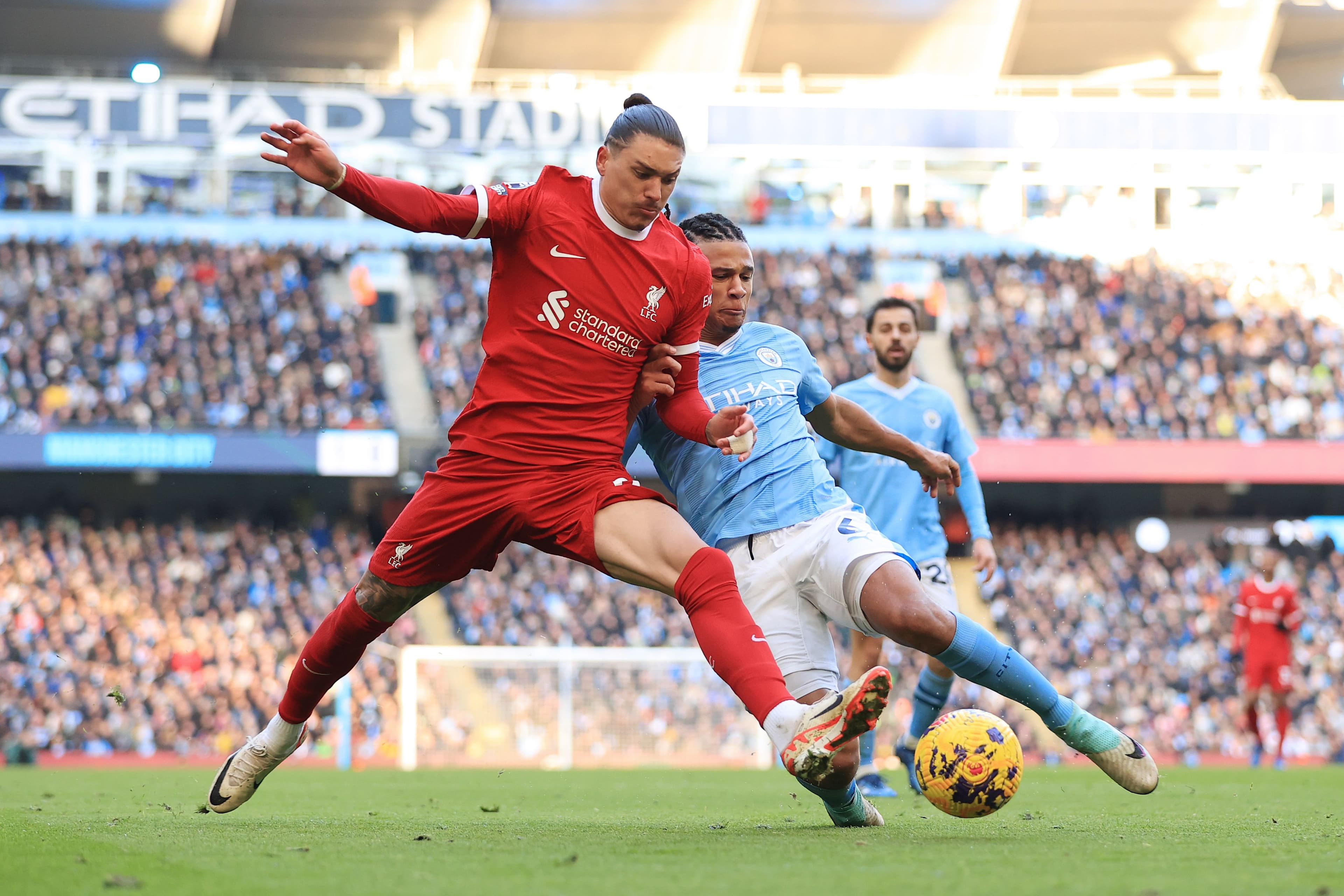Nathan Ake of Manchester City tackles Darwin Nunez of Liverpool