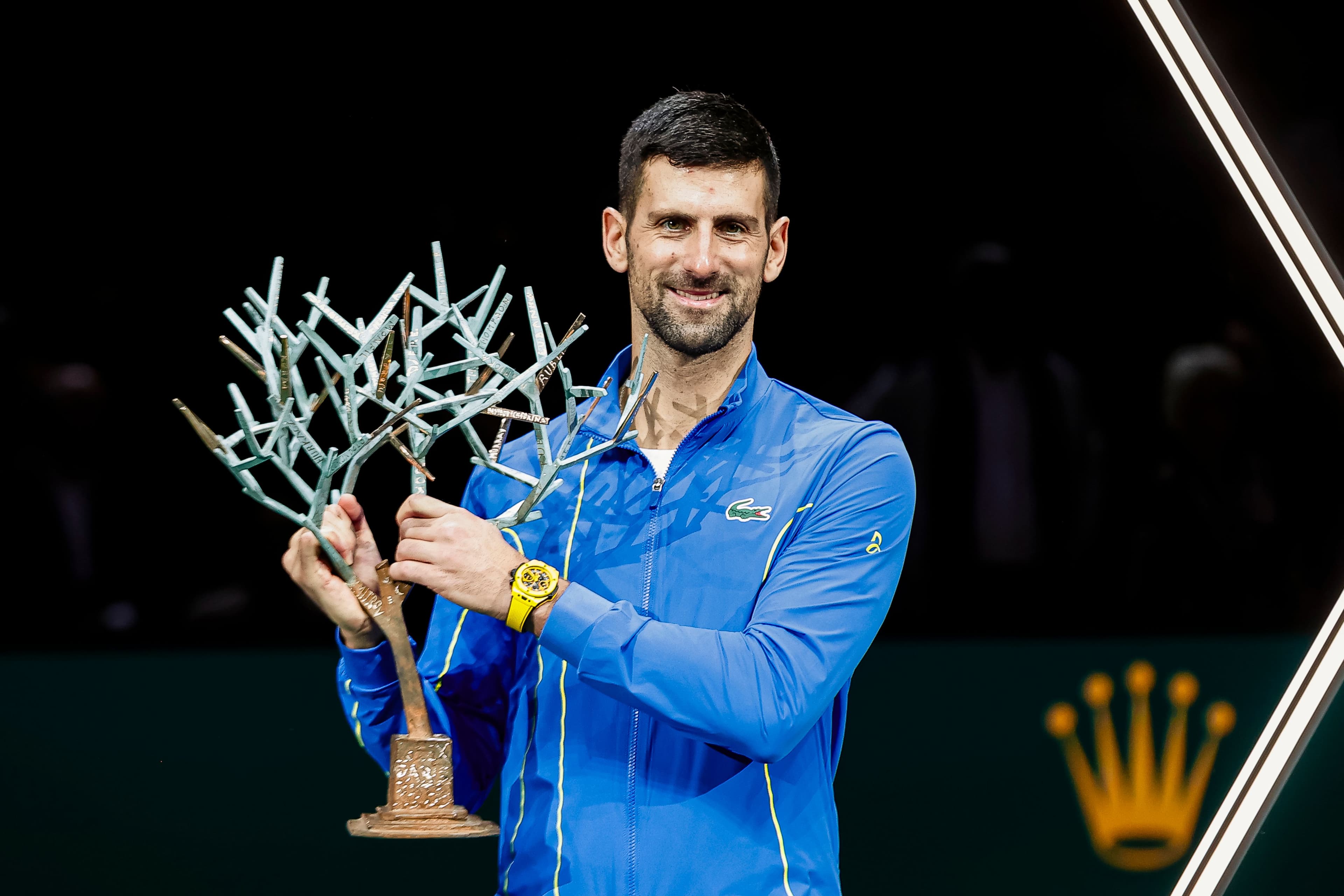 Novak Djokovic of Serbia poses for photos with the Rolex Paris Masters Winner Trophy