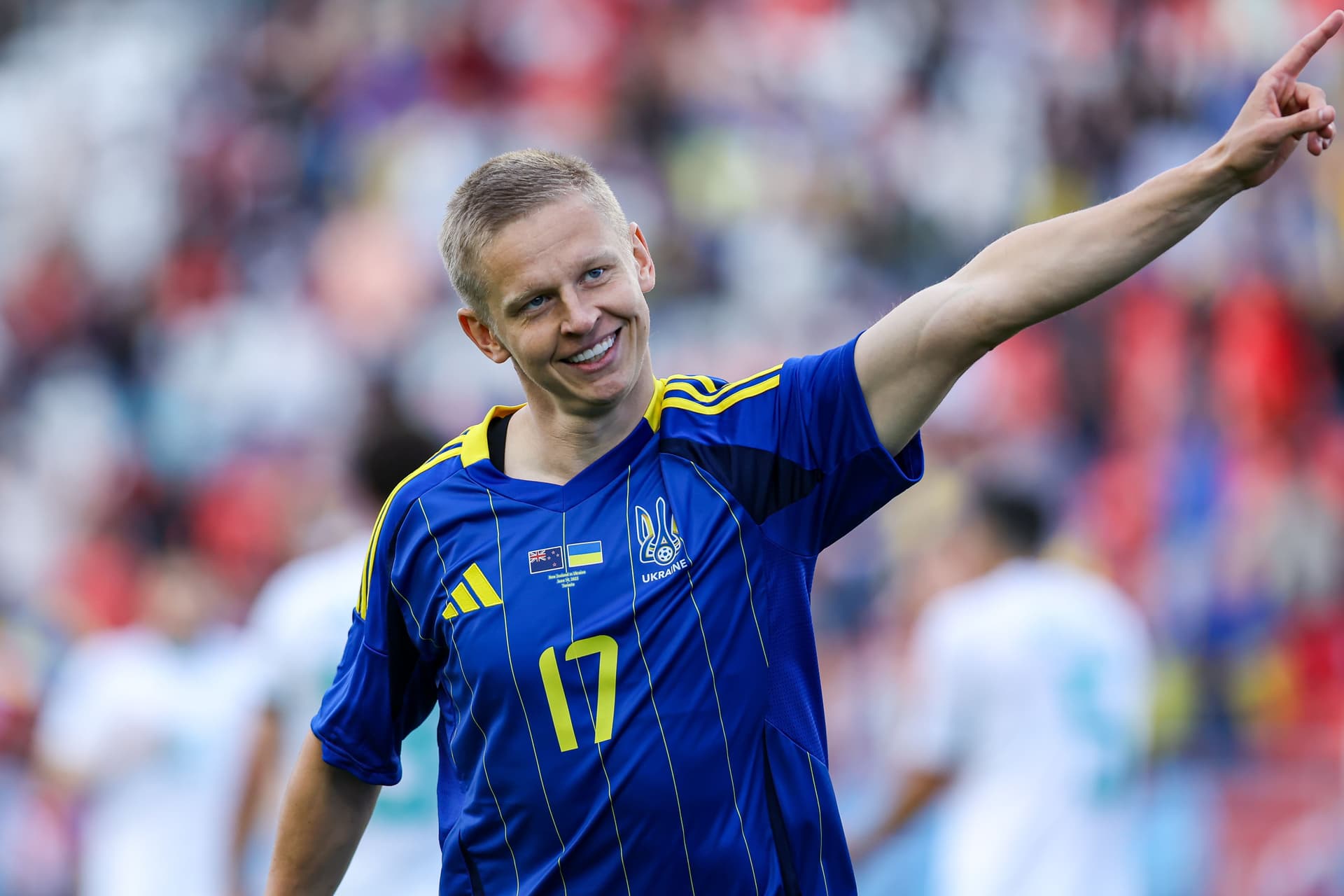 Oleksandr Zinchenko #17 (blue) celebrates his goal by pointing his finger at the supporter