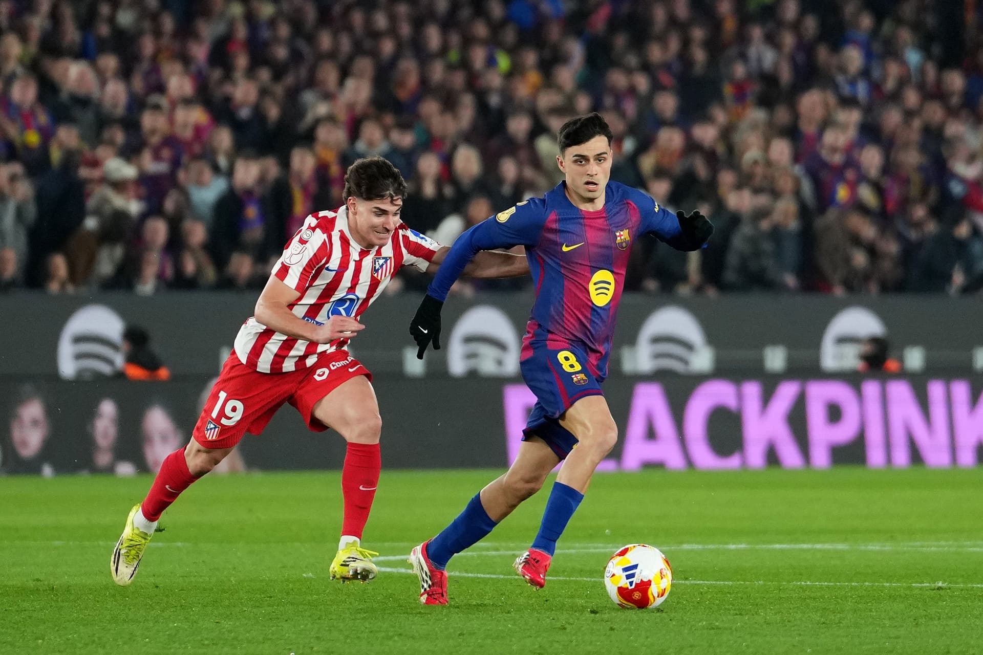 Pedri of FC Barcelona runs with the ball whilst under pressure from Julian Alvarez