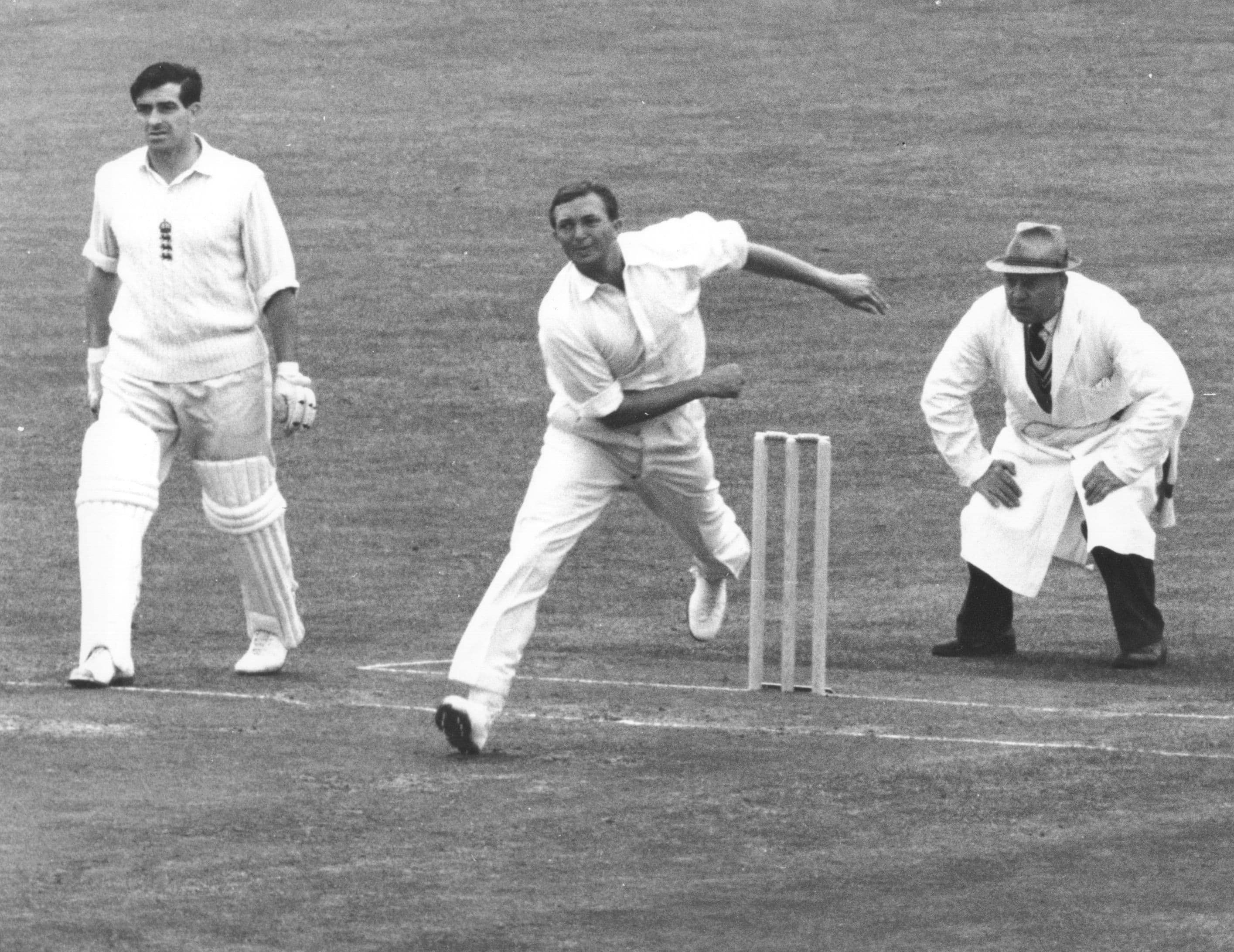 Richie Benaud of Australia is watched very carefully by the umpire
