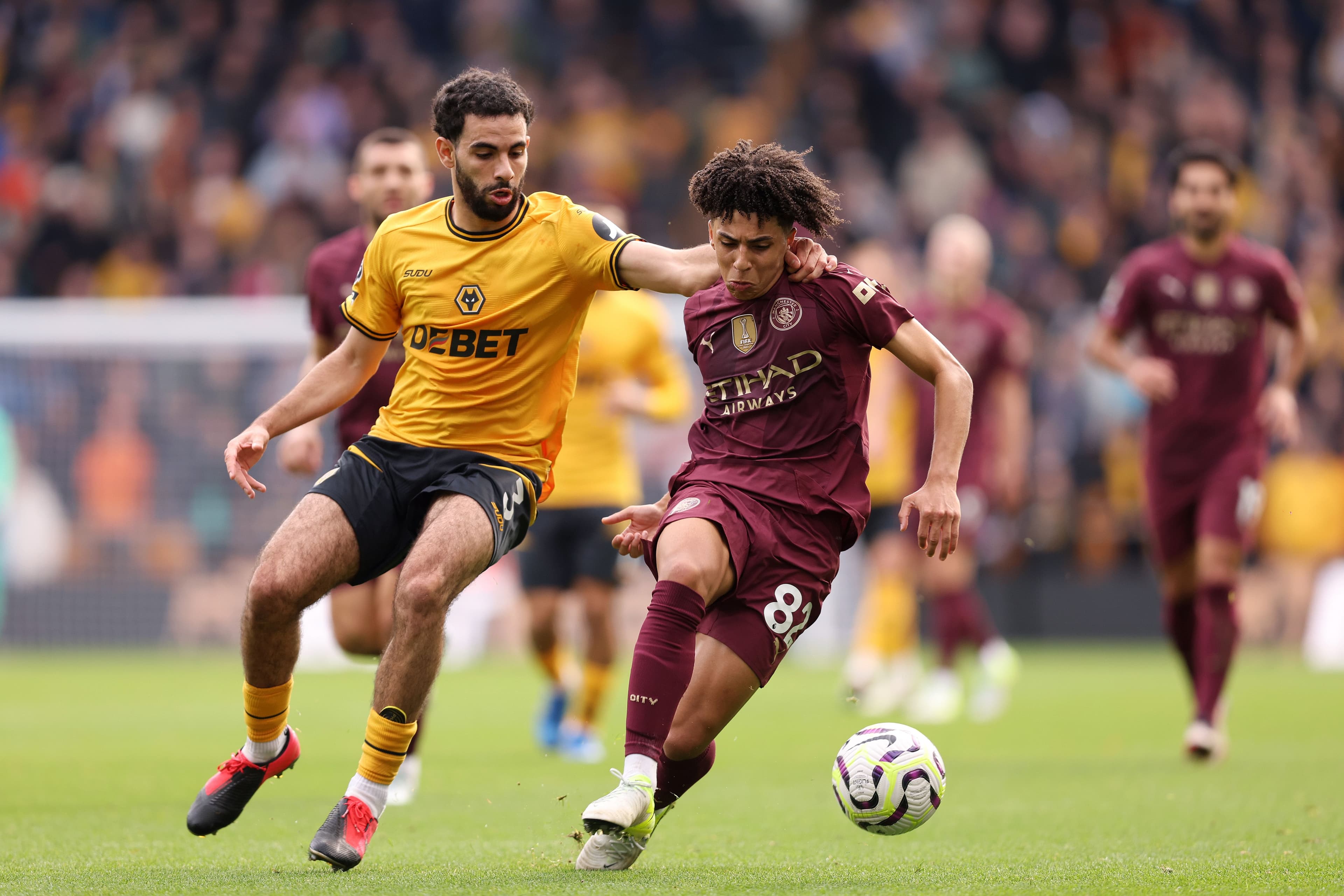 Rico Lewis controls the ball whilst under pressure from Rayan Ait-Nouri