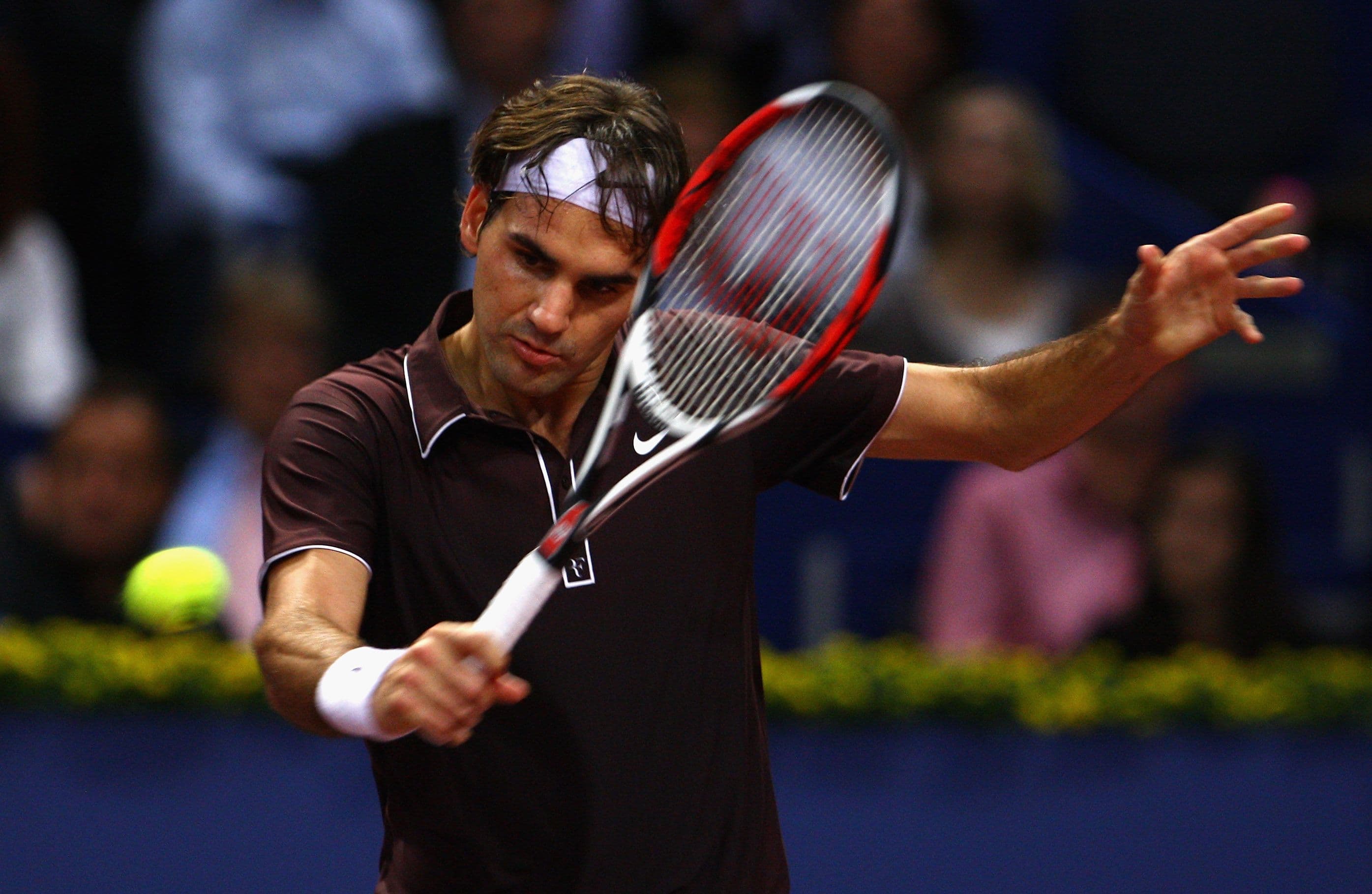 Roger Federer of Switzerland plays a backhand in his match against Olivier Rochus