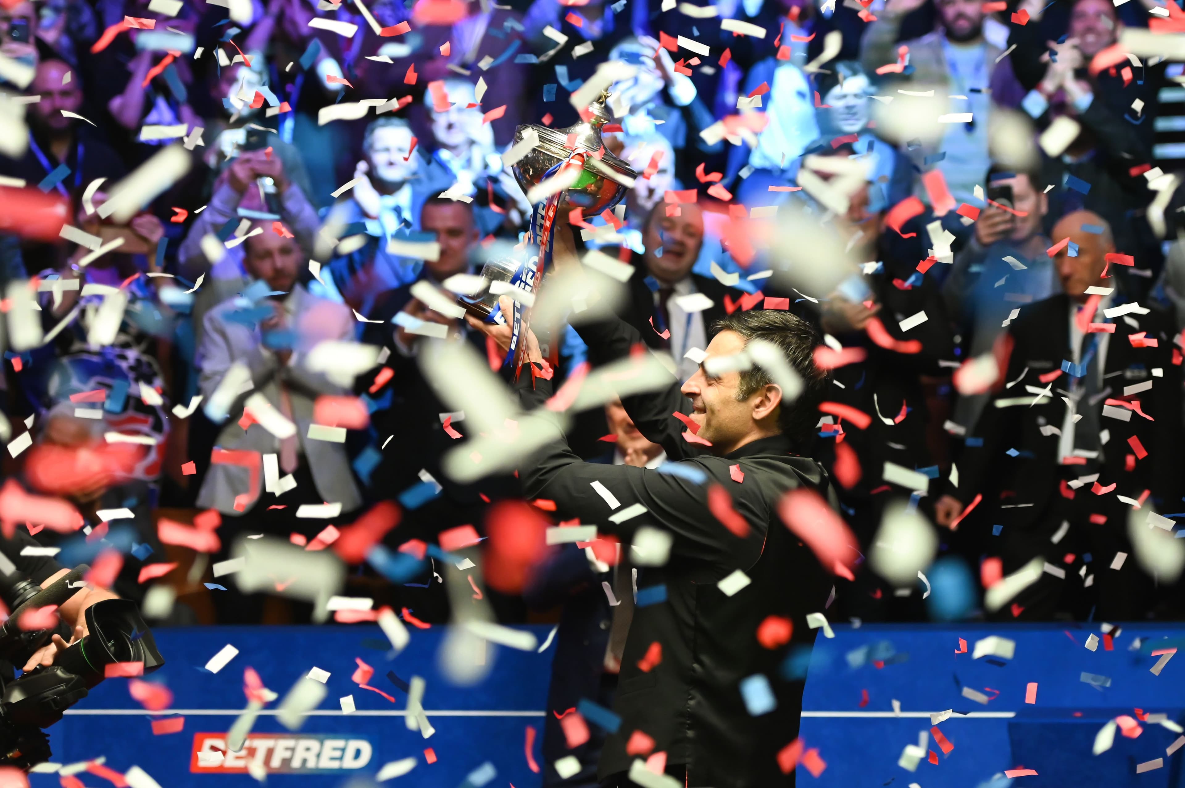 Ronnie O'Sullivan of England celebrates with the trophy after winning the final match