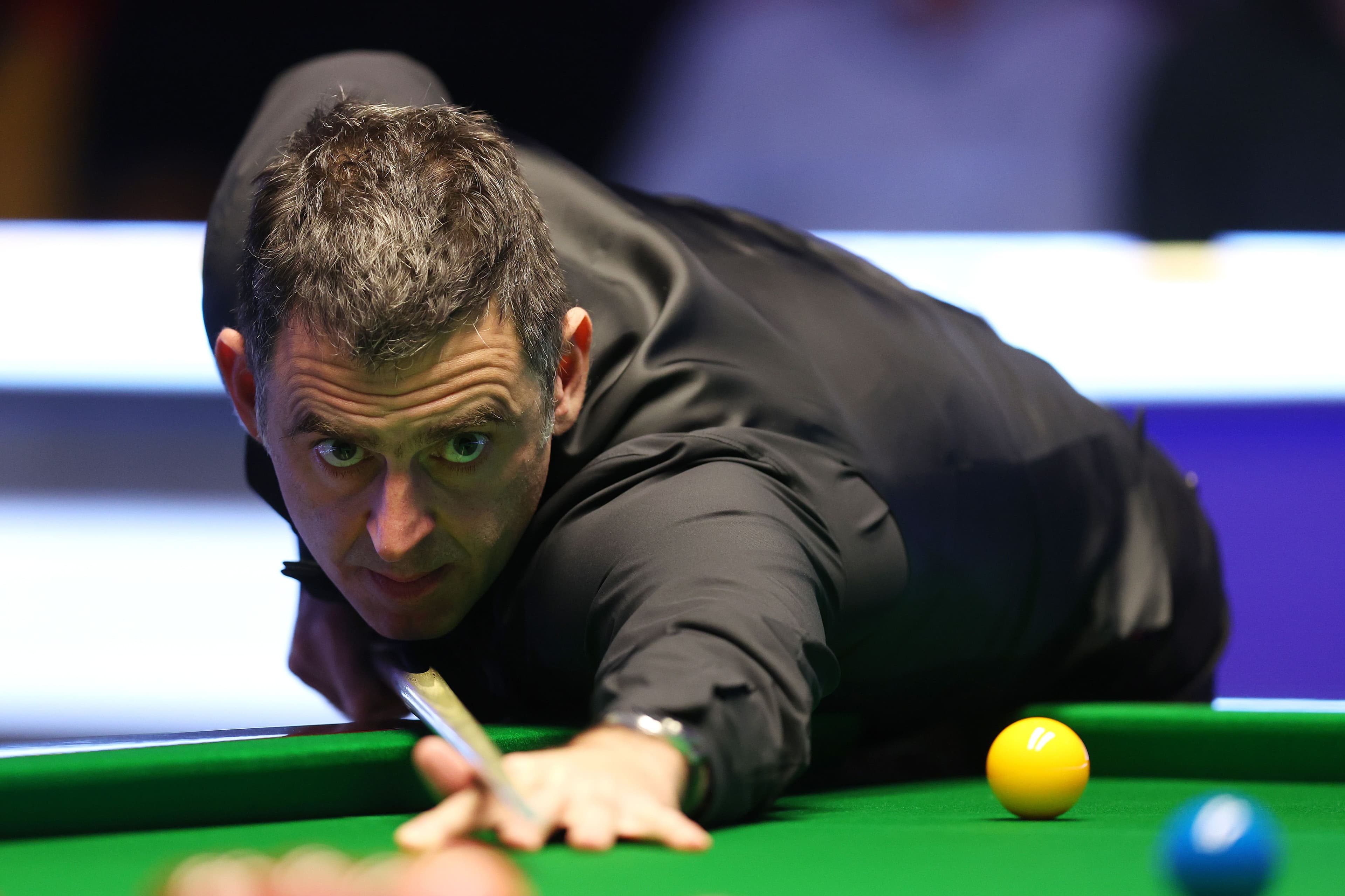 Ronnie O'Sullivan of England plays a shot against Ding Junhui of China