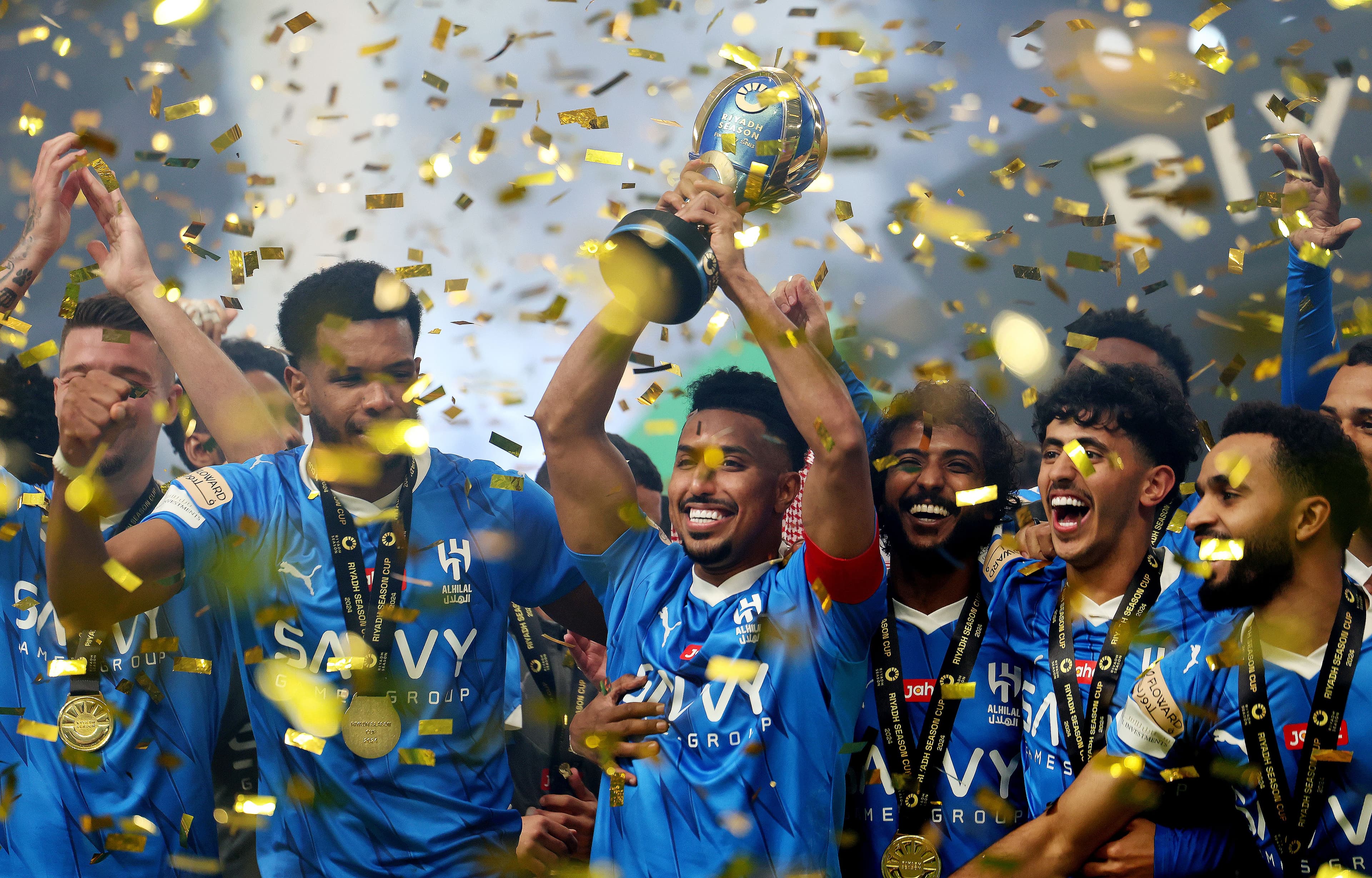 Salem Al-Dawsari of Al Hilal lifts the Riyadh Season Cup trophy as players of Al Hilal celebrate after defeating Al-Nassr